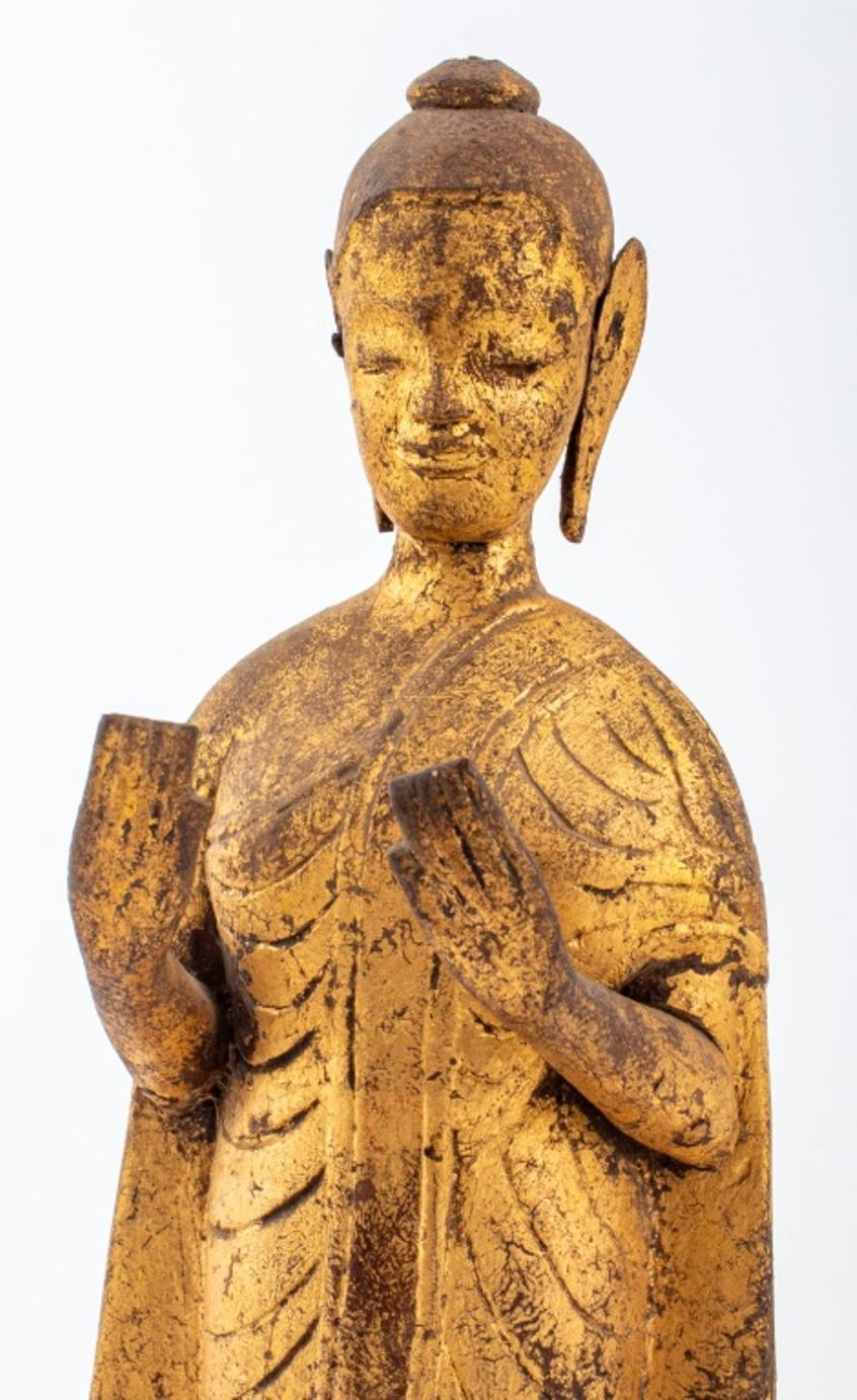 Antique Southeast Asian hand carved giltwood sculpture depicting a Buddha figure standing atop a lotus pedestal upon octagonal tiers. Provenance: From the collection of Le Lieu and Malcolm Browne (American, 1931-2012), the photojournalist who took