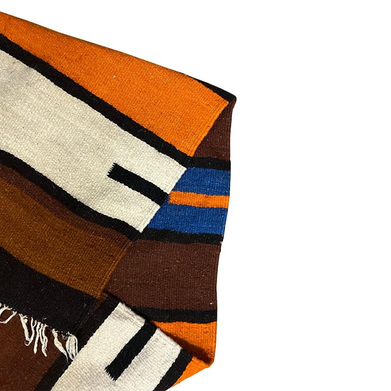 Une ancienne couverture de selle rectangulaire en laine tissée à la main. Cette pièce a été utilisée dans un ranch pour être placée sous une selle. (Il est tissé à la main et présente un motif géométrique dans les tons orange, marron, bleu et crème.