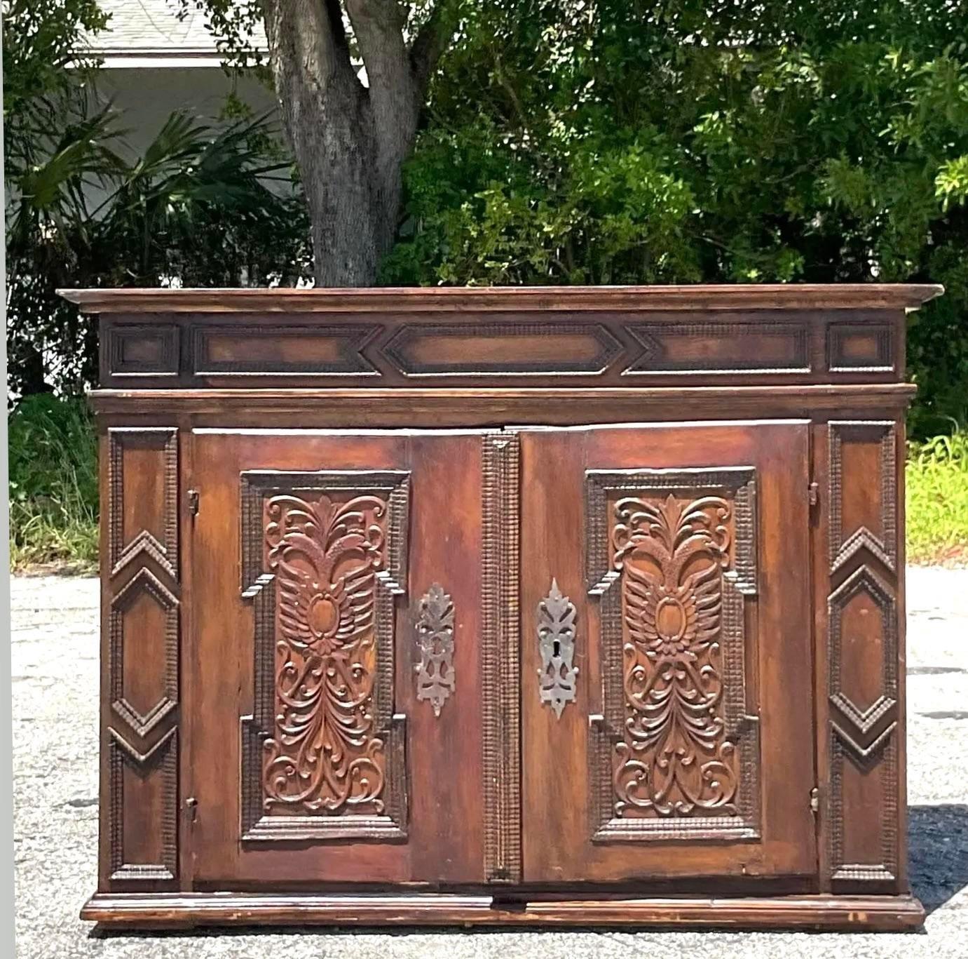 Colonial Charm: The Antique 18th Century Carved Primitive Sideboard is a testament to American craftsmanship and heritage. With its intricate carvings and rustic allure, it embodies the simplicity and warmth of early American design. A piece of