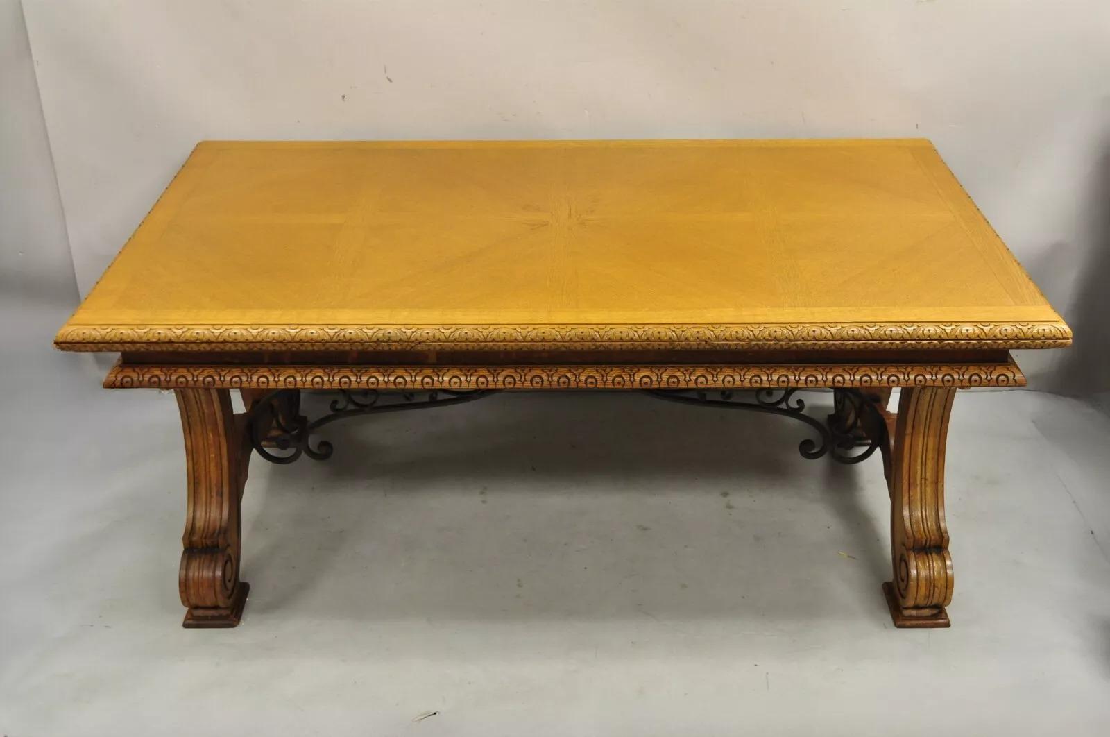Ancienne table de salle à manger à rallonge en bois de chêne sculpté, de style jacobéen/baroque espagnol. L'article comprend 2 allonges cachées, une base en fer forgé, une base et une jupe finement sculptées et un magnifique grain de bois. Circa
