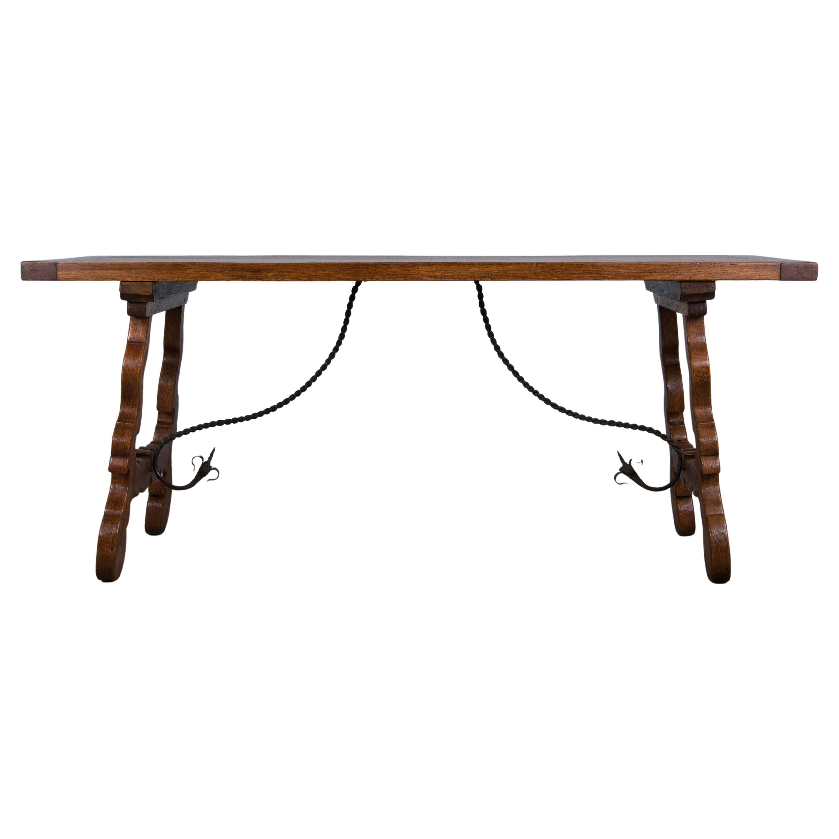 Mesa de comedor de estilo barroco español de finales del siglo XIX, procedente de Provenza, Francia. Hecha a mano por expertos con madera de roble maciza, tiene un robusto tablón rectangular de 1,65 m de grosor con extremos de tablero y espigas de