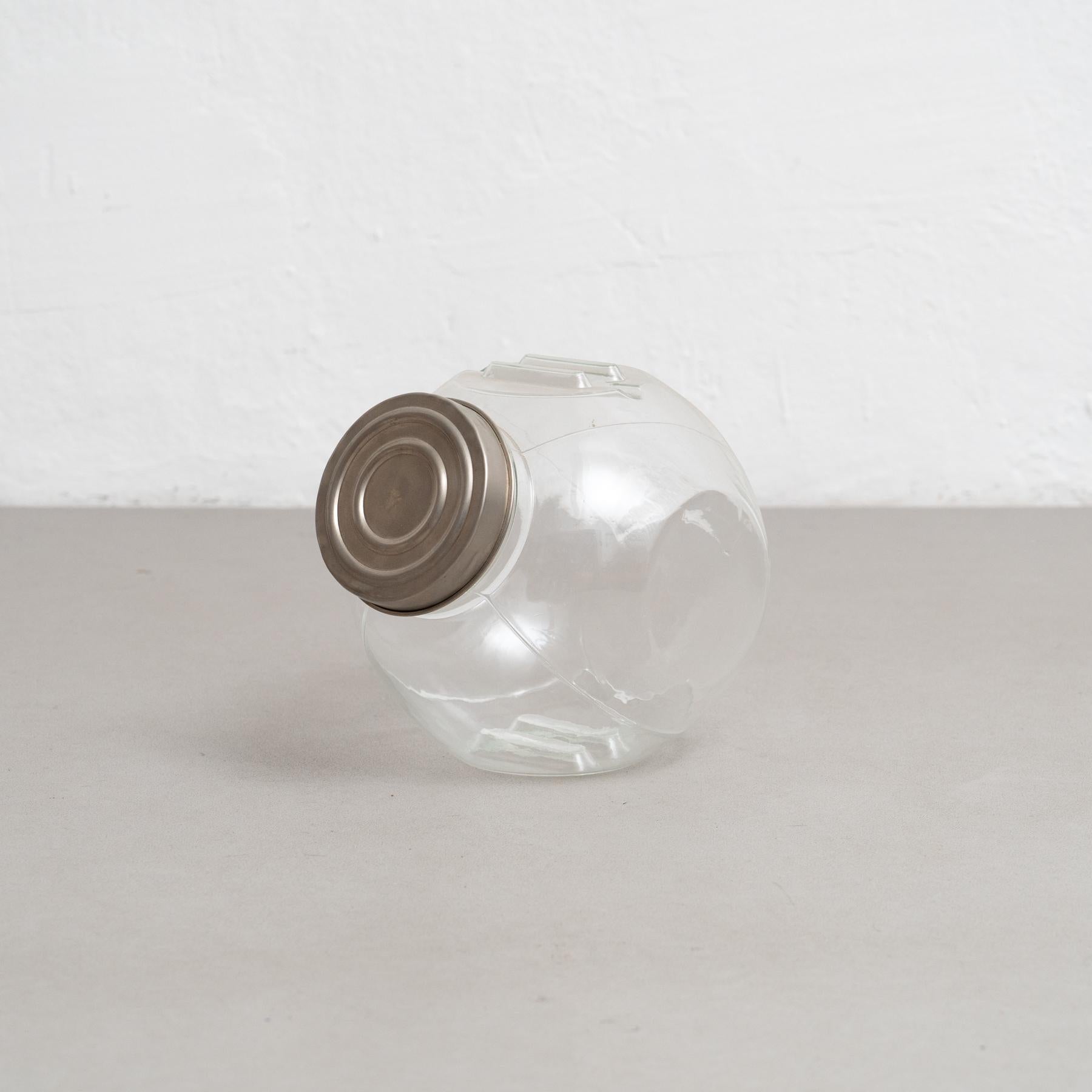 Antique glass container with a metal cap. 

Step into a realm of refined sophistication with this captivating antique glass container, complete with a gracefully adorned metal cap. Meticulously crafted in Spain around the year 1930 by an unknown