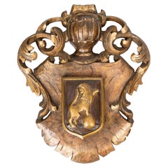 Ancienne plaque murale espagnole en bois doré sculpté représentant des armoiries héraldiques et un bouclier