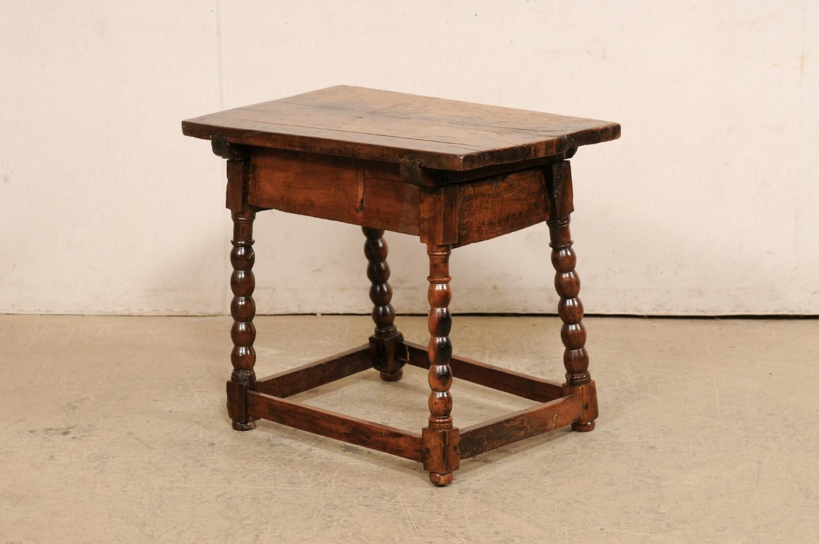 A Spanish occasional table with drawer, from the turn of the 18th and 19th century. This antique table from Spain has a rectangular-shaped top, which overhangs the apron below which houses a single dovetailed-drawer at one long side, which is adorn