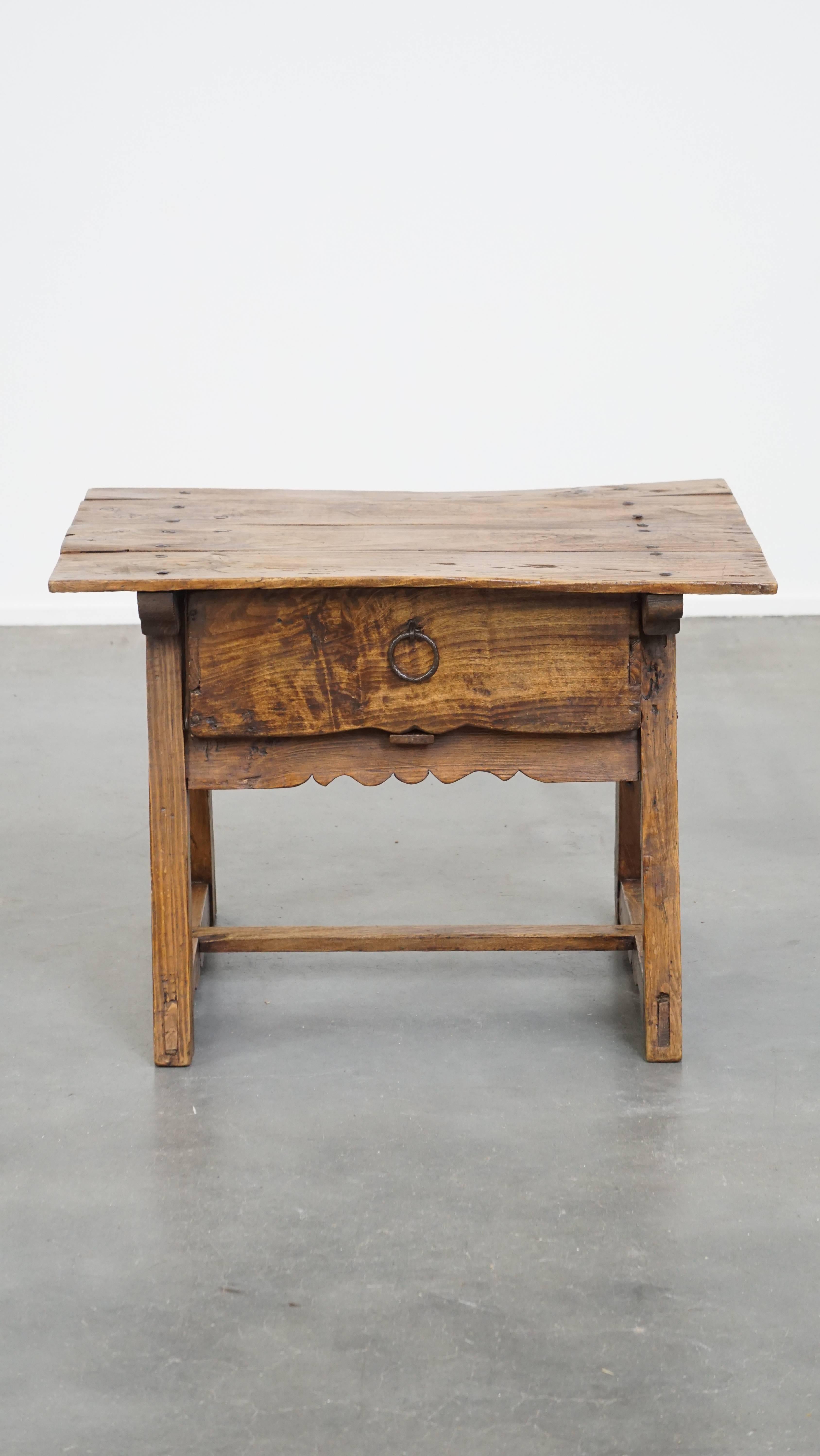 Questo splendido tavolino d'epoca spagnolo è realizzato in legno di frutto e, grazie al suo design senza tempo, si adatta perfettamente a qualsiasi ambiente. È ricco di notevoli dettagli originali, come i chiodi forgiati a mano che ne esaltano la