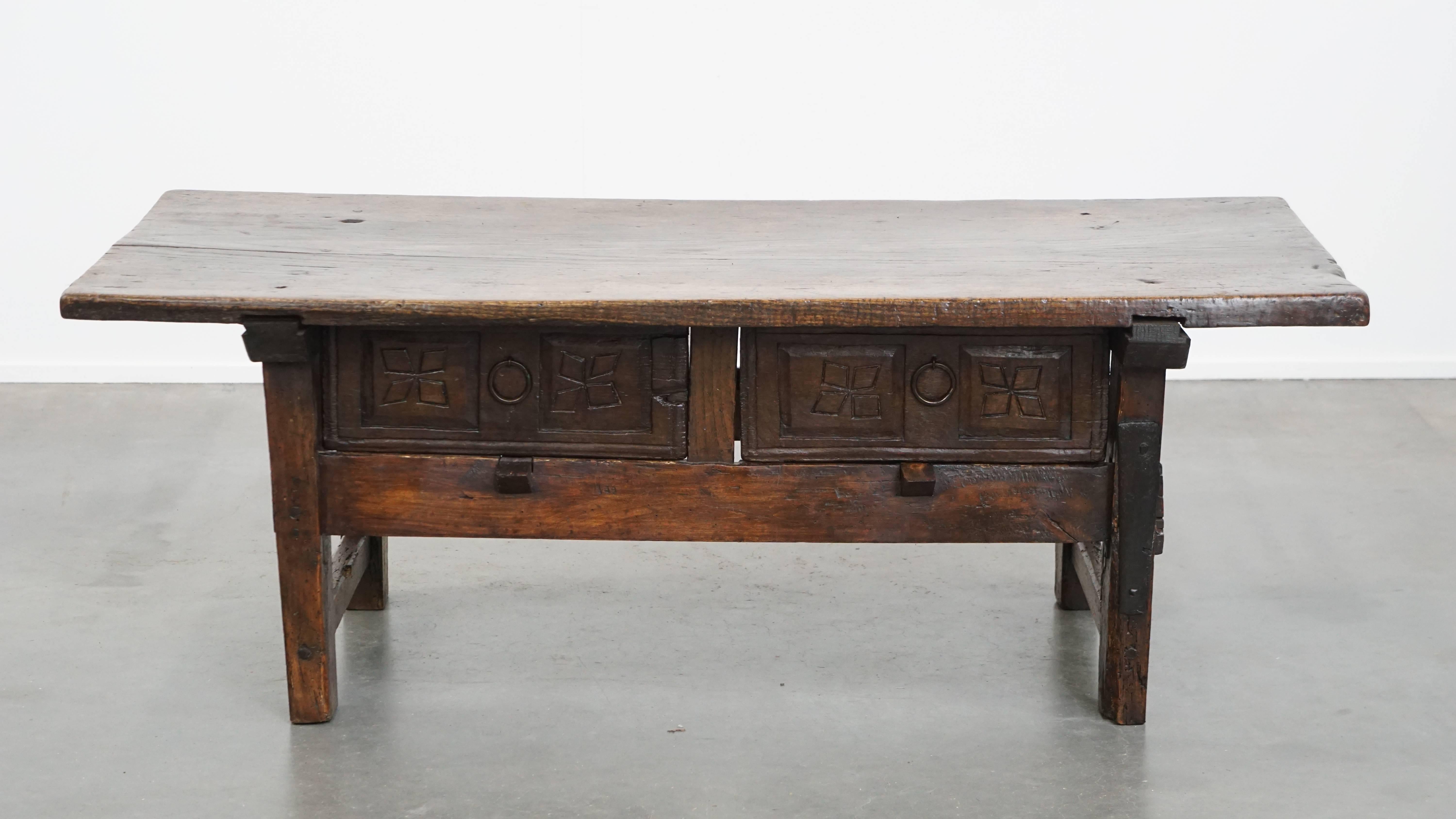 Offered here this robust and characterful antique Spanish coffee table from the 17th century with two drawers and a solid top.

How fantastic is this striking antique Spanish coffee table from the 17th century? The impressive tabletop is made from a