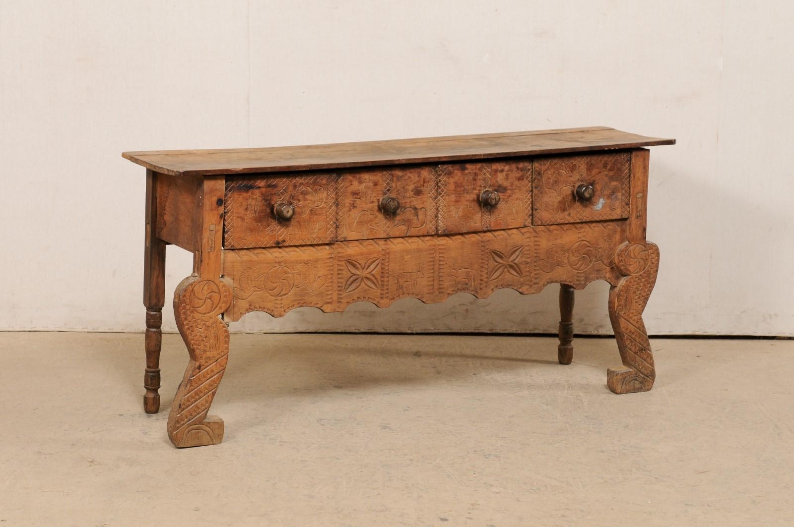 A Spanish Colonial carved wood credenza with drawers and primitive-style carvings, from the early 20th century. This antique console table from Mexico has a carved-front facade which features a whimsical display of swirling medallions, flower heads,