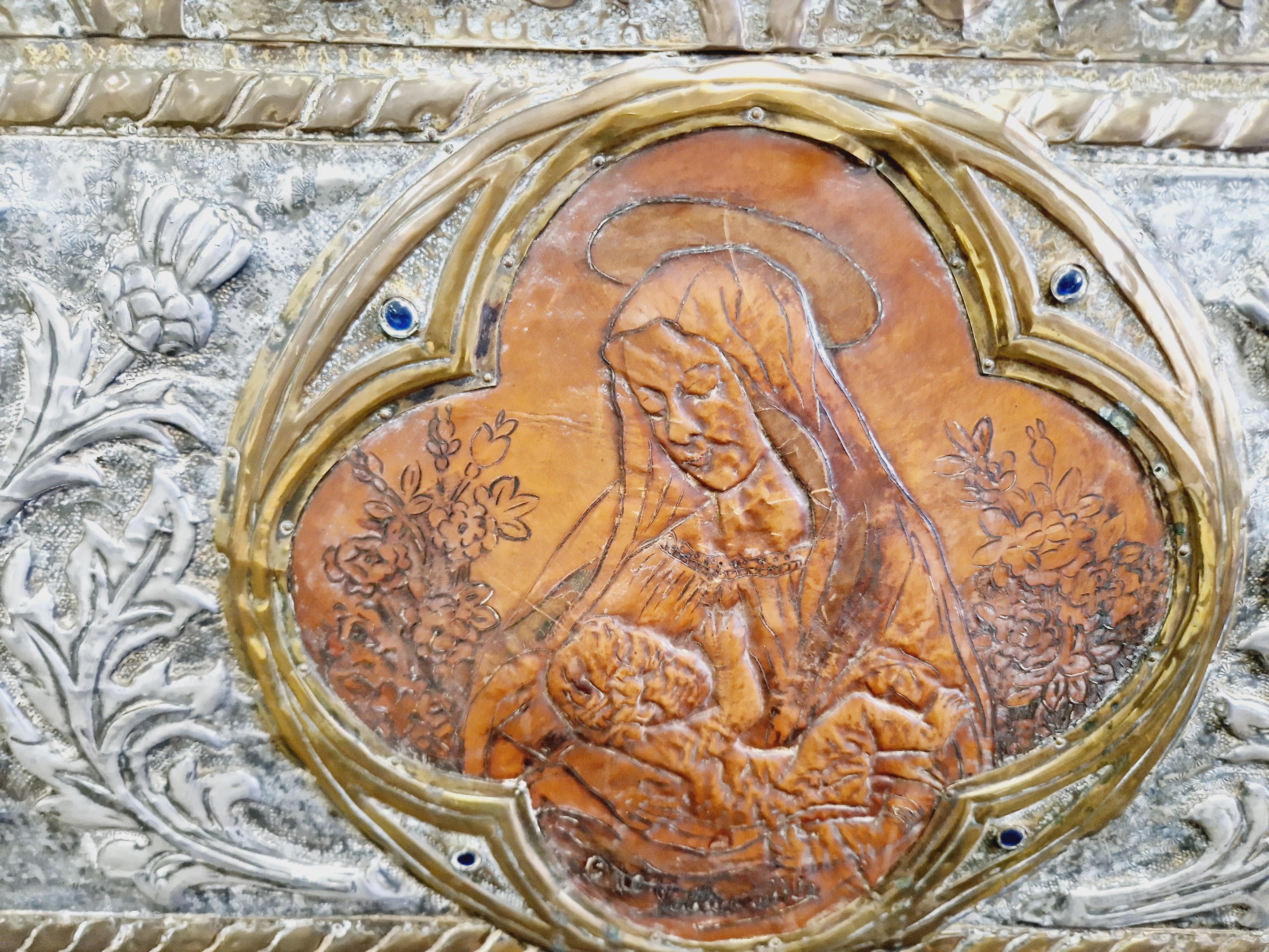 Ajoutez une touche d'histoire à votre pièce avec ce magnifique canapé Coloni espagnol ancien. Fabriqué en bois, avec un placage en métal gaufré et des détails en laiton, ce canapé présente un design complexe avec des motifs religieux, des dragons et