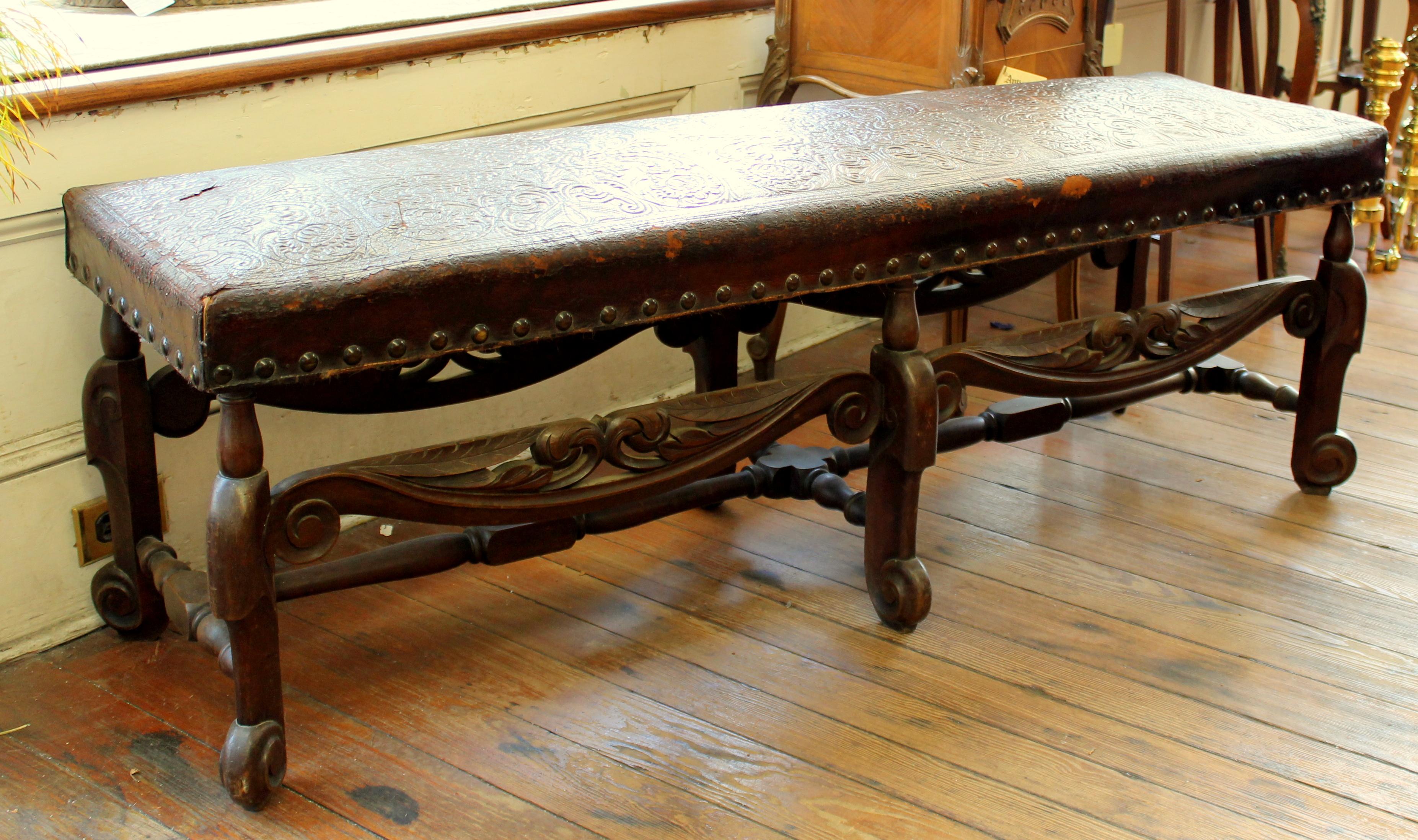 Antique Spanish carved mahogany embossed leather long bench with original embossed leather and wonderfully hand-carved bench. Five feet long! Very rare and fine. Some small tears to leather noted (and illustrated.)