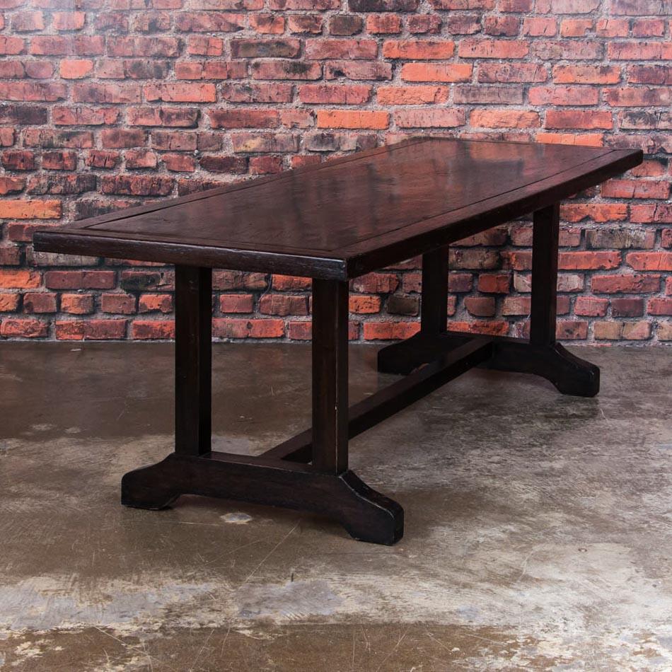  This long handcrafted dining table with it's framed top and square legs in a rich mahogany color, makes a bold statement. Made from endemic Philippine hardwoods, possibly molave wood, the table has an open feel with the narrow legs and trestle