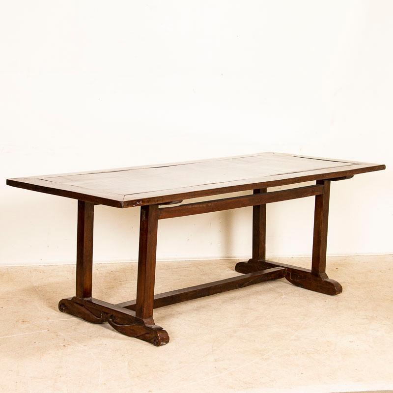 This striking dining table is a combination of Spanish colonial style crafted from the beautiful and extremely hard narra wood from the Philippines. Examine the photos to appreciate the dark, rich patina and sheen which invites one to run fingers