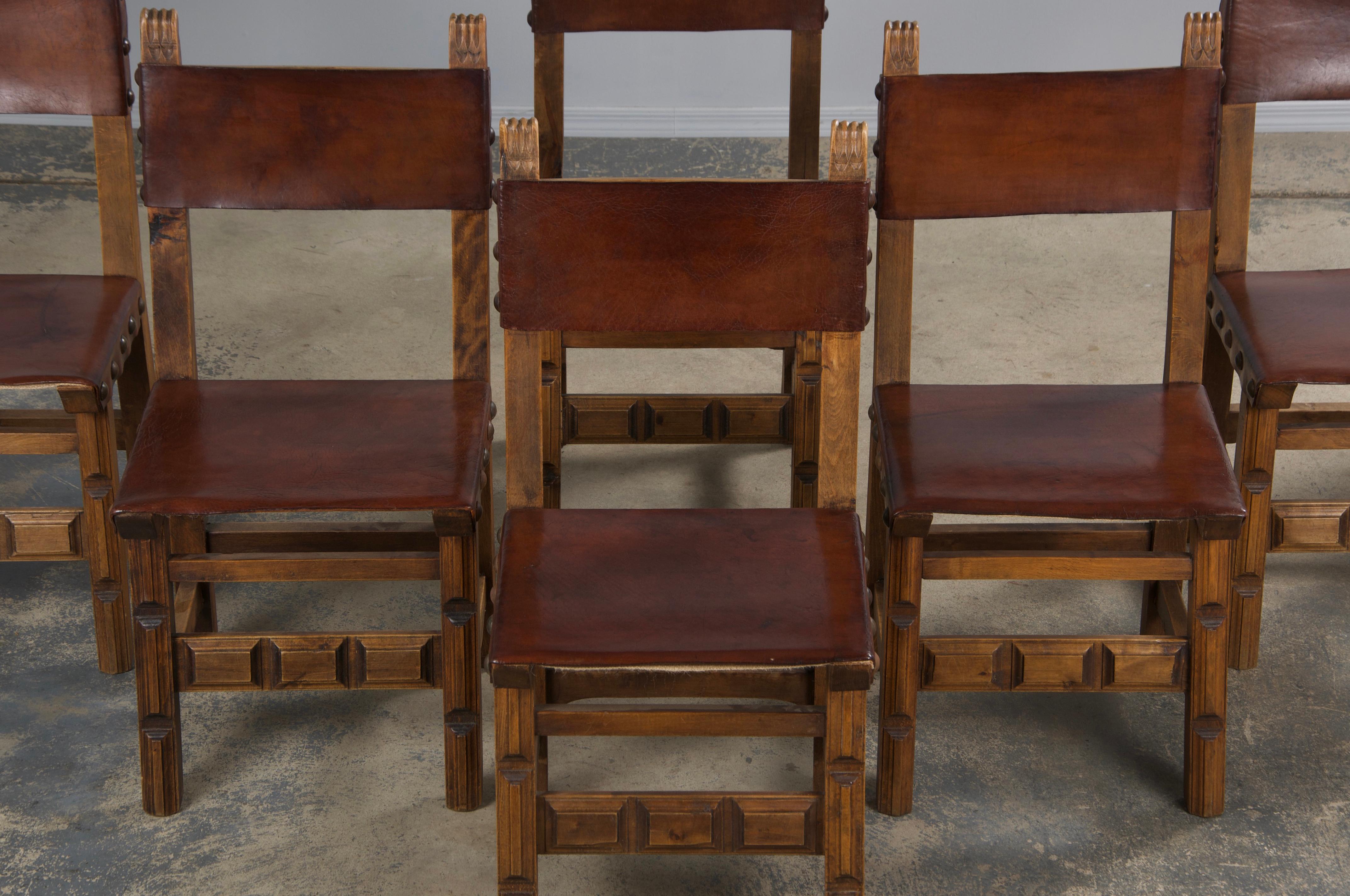 A handsome set of eight late 19th-century Spanish Colonial-style dining chairs, sourced from Provence, France. Beautifully handcrafted from solid oak, these chairs feature intricately hand-carved frames. Structurally restored for stability, they