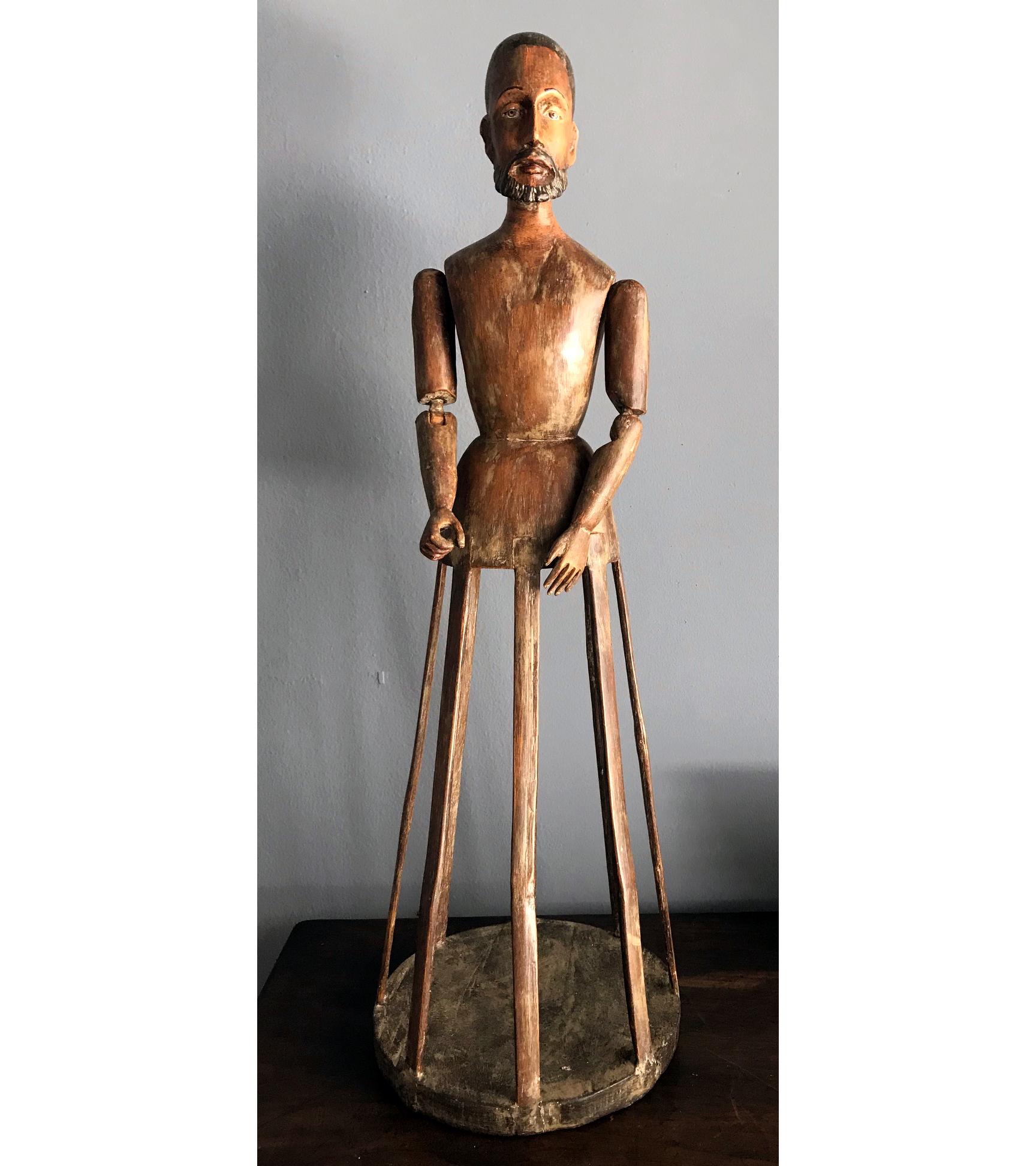 A wonderful antique Santo carved in wood with articulated arms and a slatted base from Spanish Colonial Latin America, likely Mexico. Wonderful patina with detailed facial feature and glass eyes. This kind of Santos are also known as the 