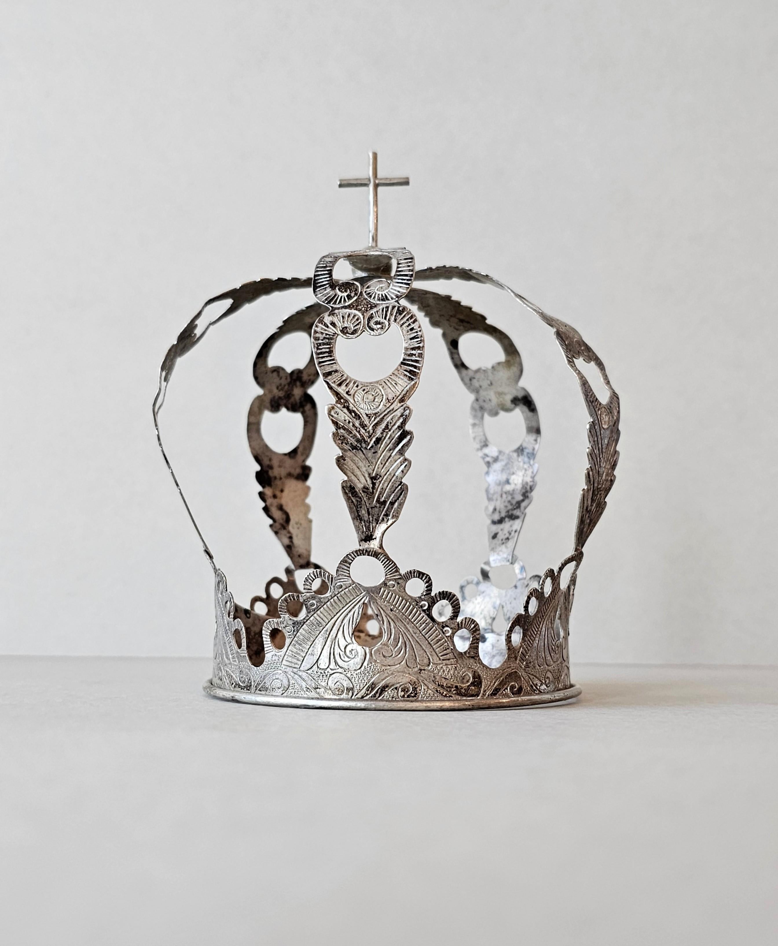 A scarce 19th century Spanish Colonial style silver saint's crown, to be mounted on the head of a church altar figure, having a cross finial, pierced arches with foliate motif and finely engraved ornamentation. 

A superb museum quality example,