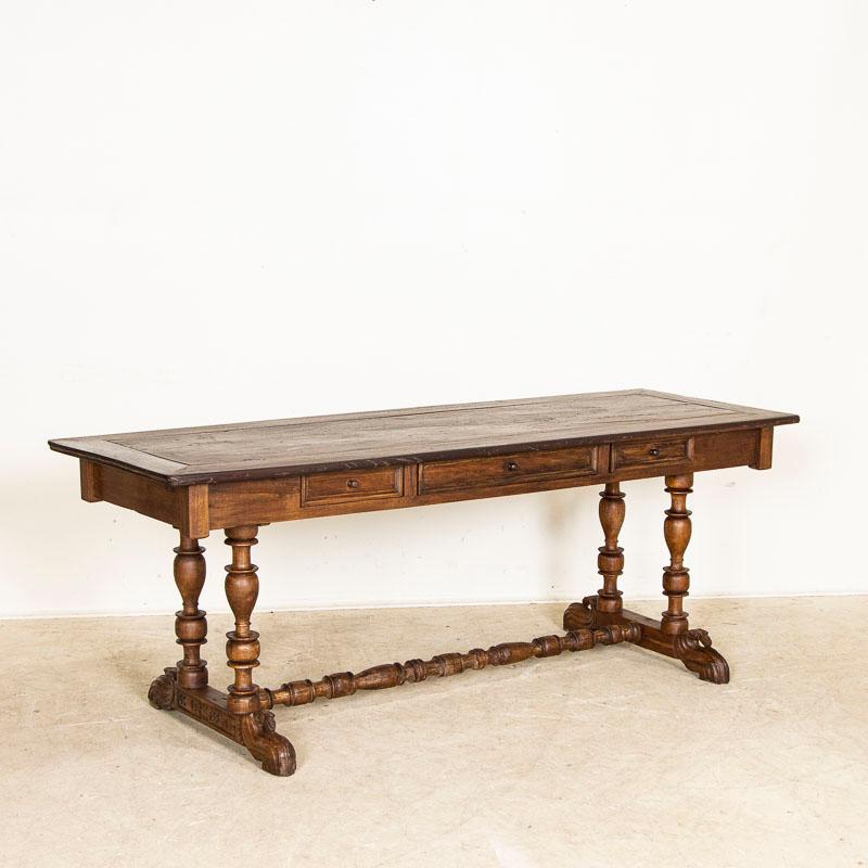 This antique Spanish Colonial table is supported by intriguing turned legs supported by broad feet and connected by a low turned stretcher. Unique carvings in the leg base and feet add to the lovely appeal. The 