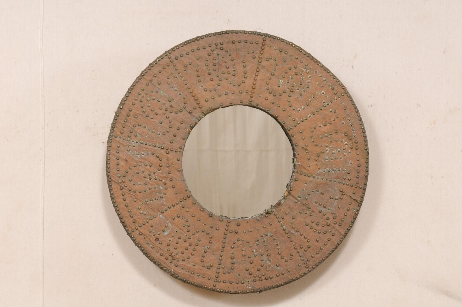 Miroir espagnol, avec entourage de brasero en cuivre, du tournant des 19e et 20e siècles. Ce miroir circulaire unique a été fabriqué sur mesure à partir d'un brasero espagnol antique, entouré d'une feuille de cuivre et magnifiquement orné d'une tête