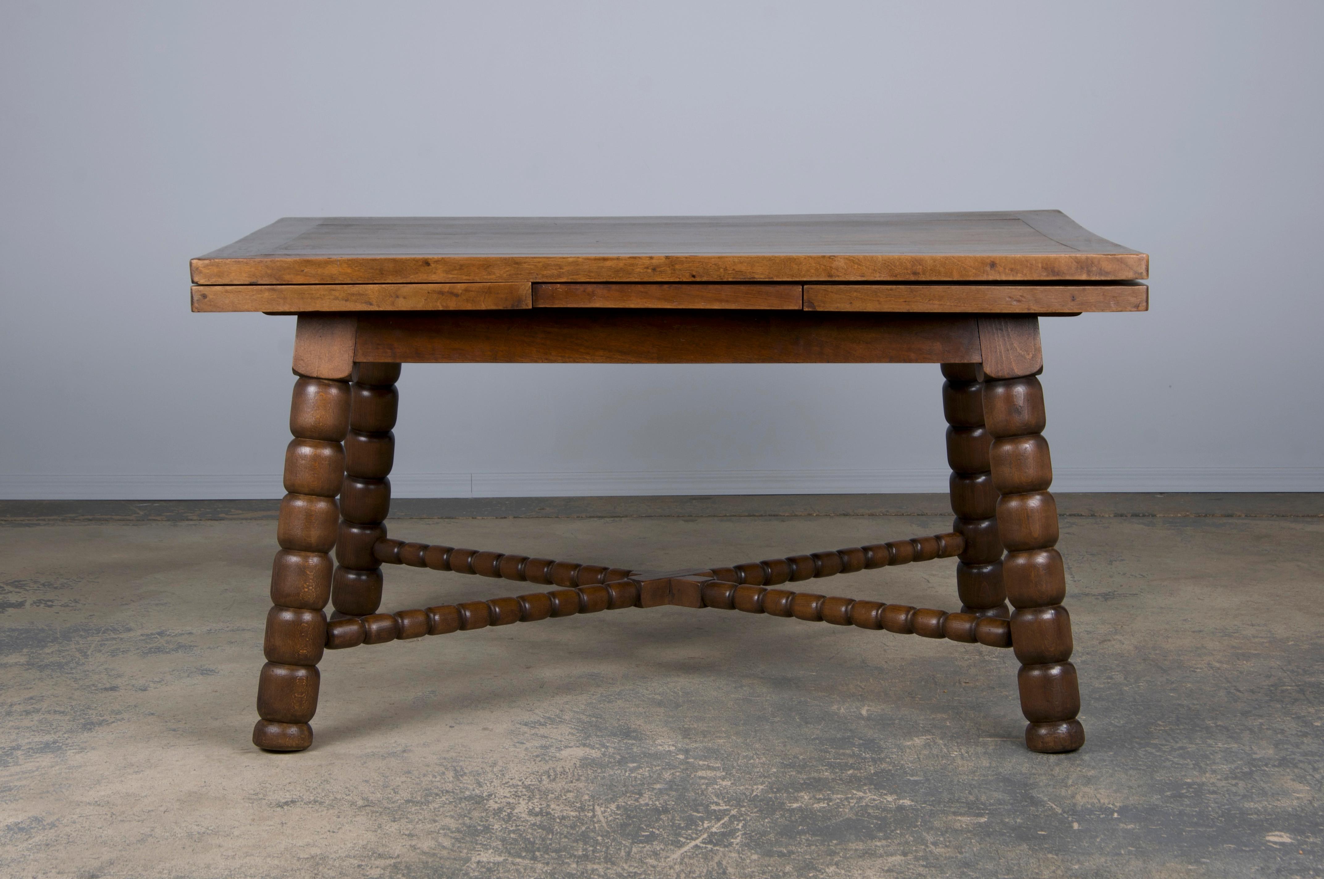 Charmante table de salle à manger espagnole de la fin du XIXe siècle, provenant de Provence, France. Fabriquée à la main à partir de bois massifs mélangés, la table affiche une patine naturellement vieillie avec de riches tons bruns et un grain de