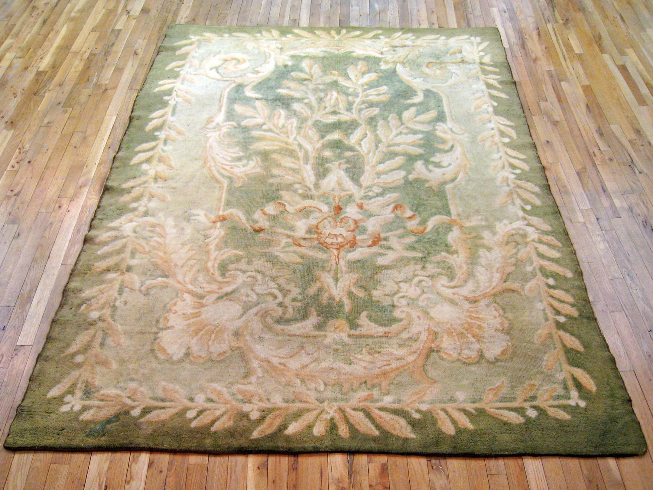 Antique Spanish Savonnerie rug, Room size, circa 1910

A one-of-a-kind antique European Savonnerie Oriental Carpet, hand-knotted with short wool pile. This beautiful rug features floral elements allover the green primary field, with ivory outer