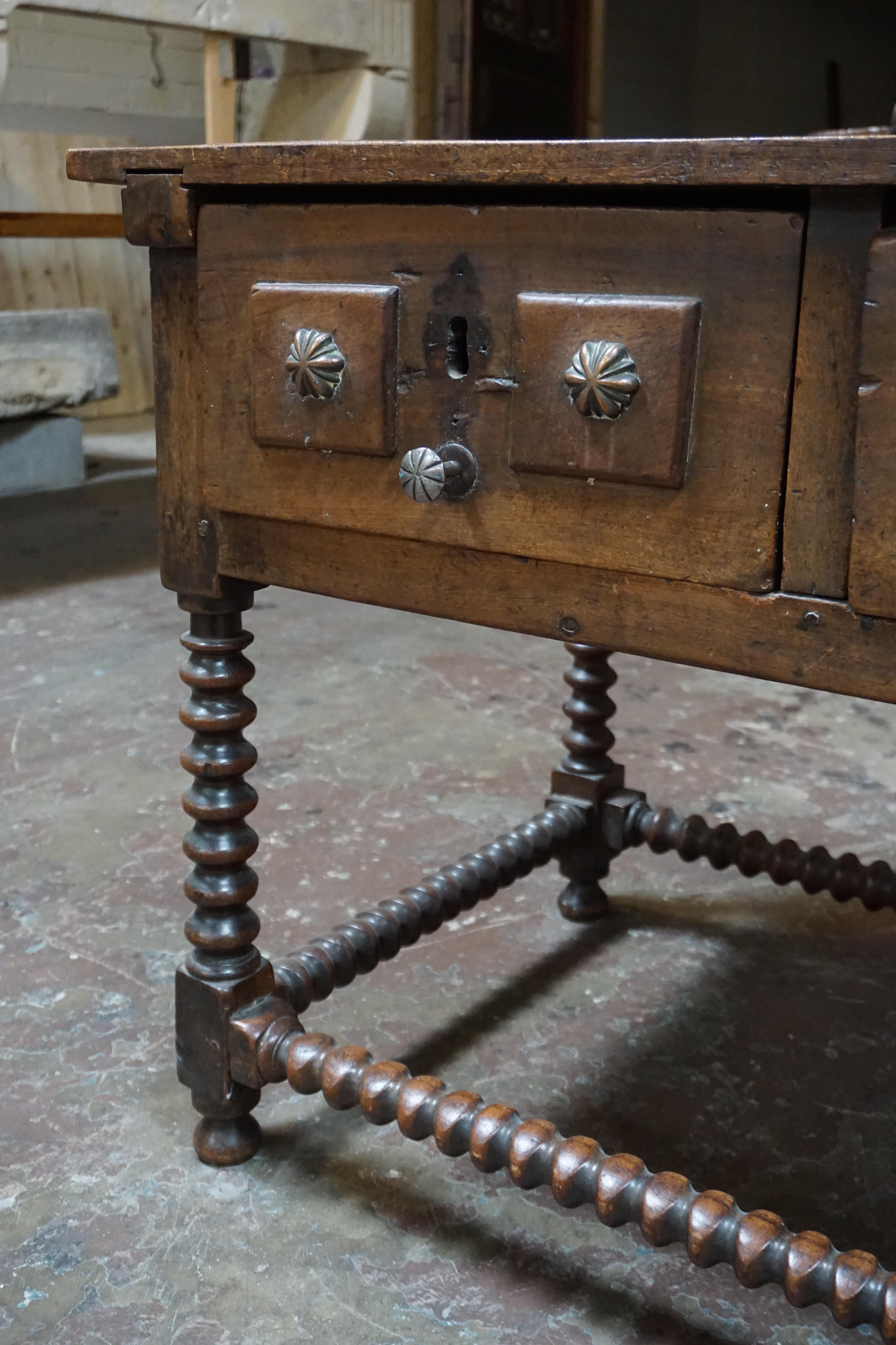 This antique desk originates from Spain, circa 1800. Small drawers on both sides, and two larger drawers in front. 

Measurements: 43'' W x 26'' D x 30.5'' H.