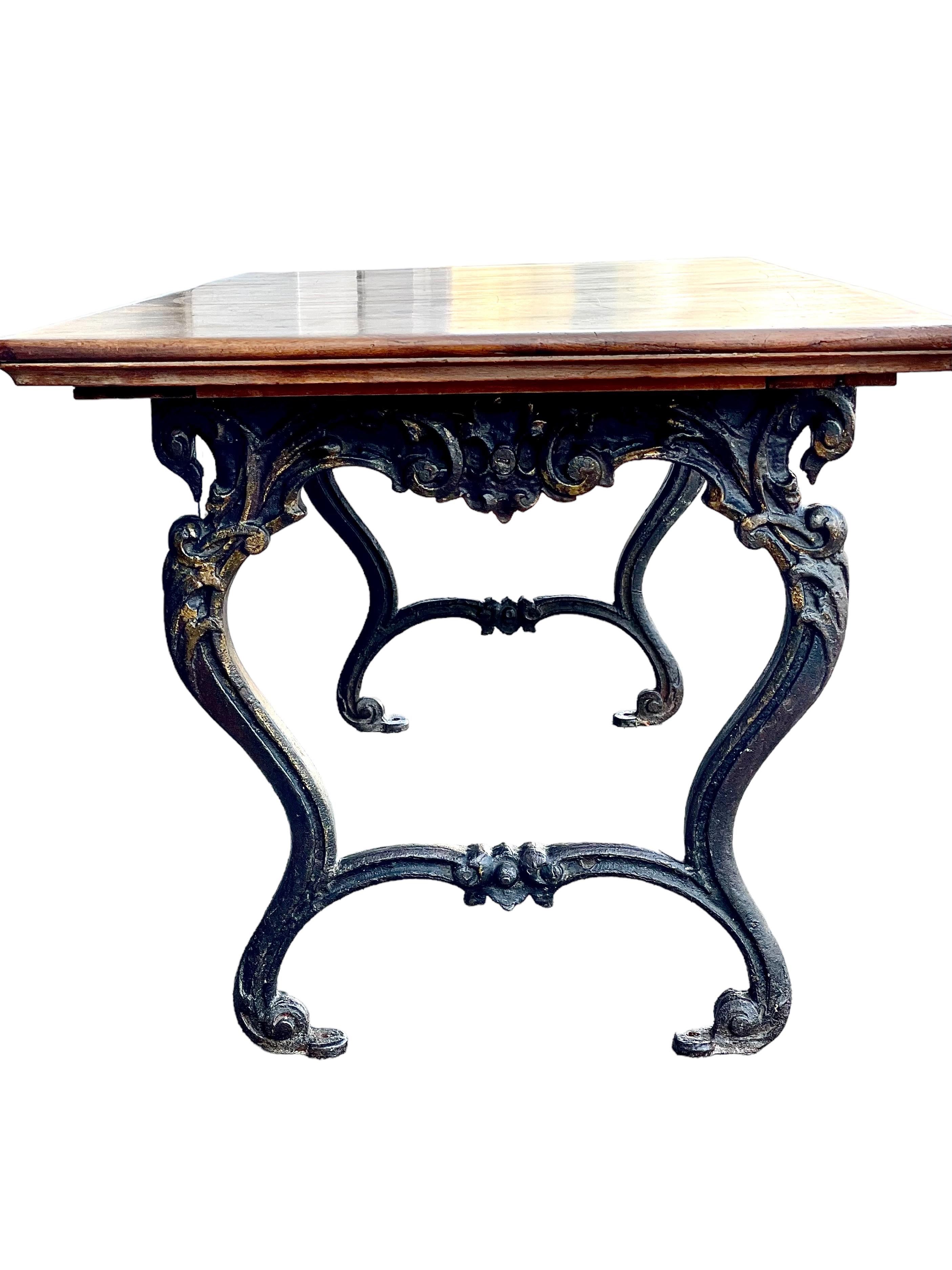 An unusual and fantastically ornate antique table, possibly originating from Spain, complete with beautifully curved and scrolled cast-iron legs. Full of character, its base is wonderfully aged and embellished with swirling and highly decorative