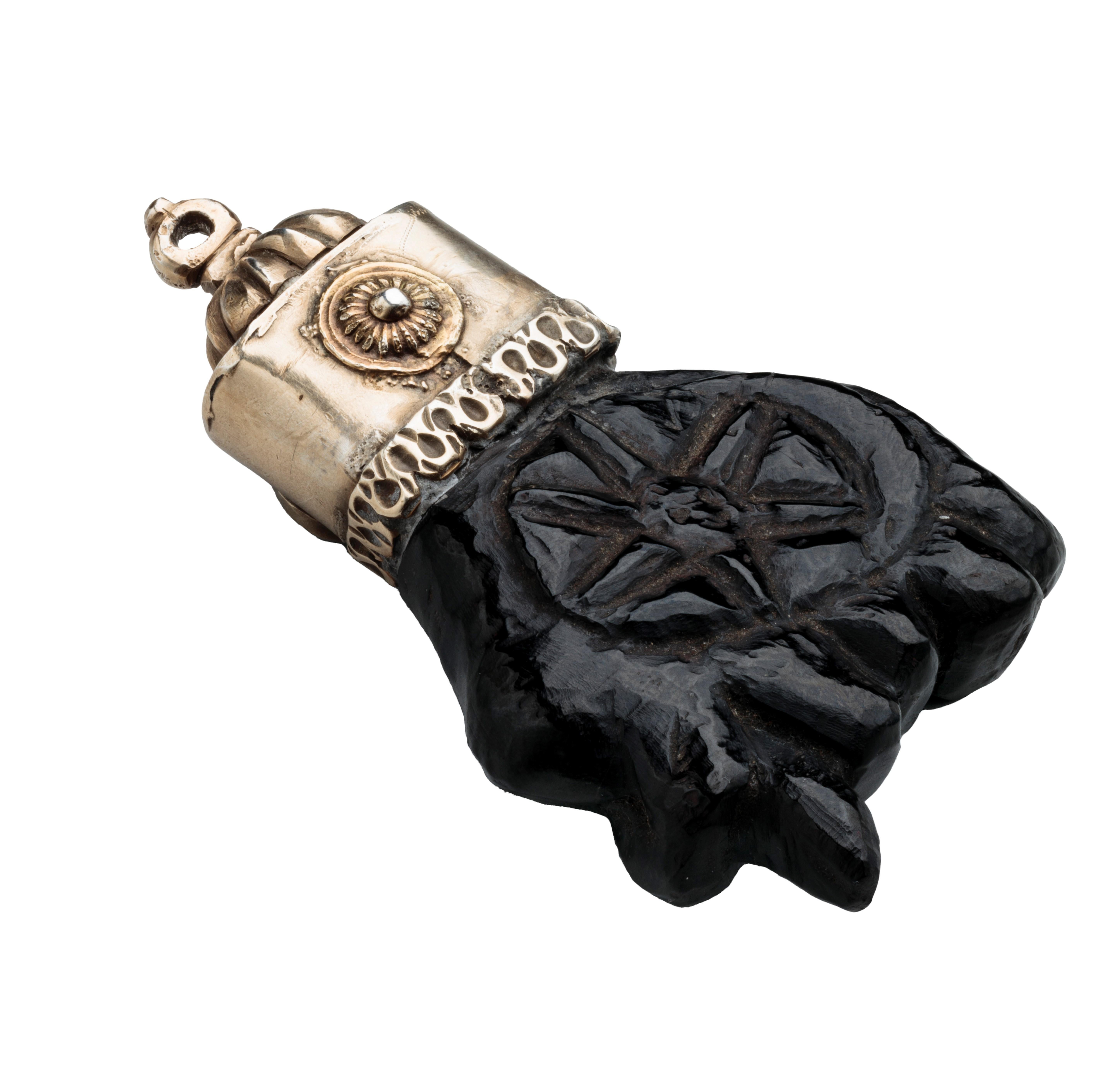 AMULET PENDANT WITH FIGA 
Spain, c. 1620–1630 
Jet, silver, and enamel 
Weight 60.7 grams; dimensions 85 × 49 × 18 mm 

Large pendant in the shape of a hand carved from jet with a clinched fist in the figa (Spanish higa) gesture. In the palm of the
