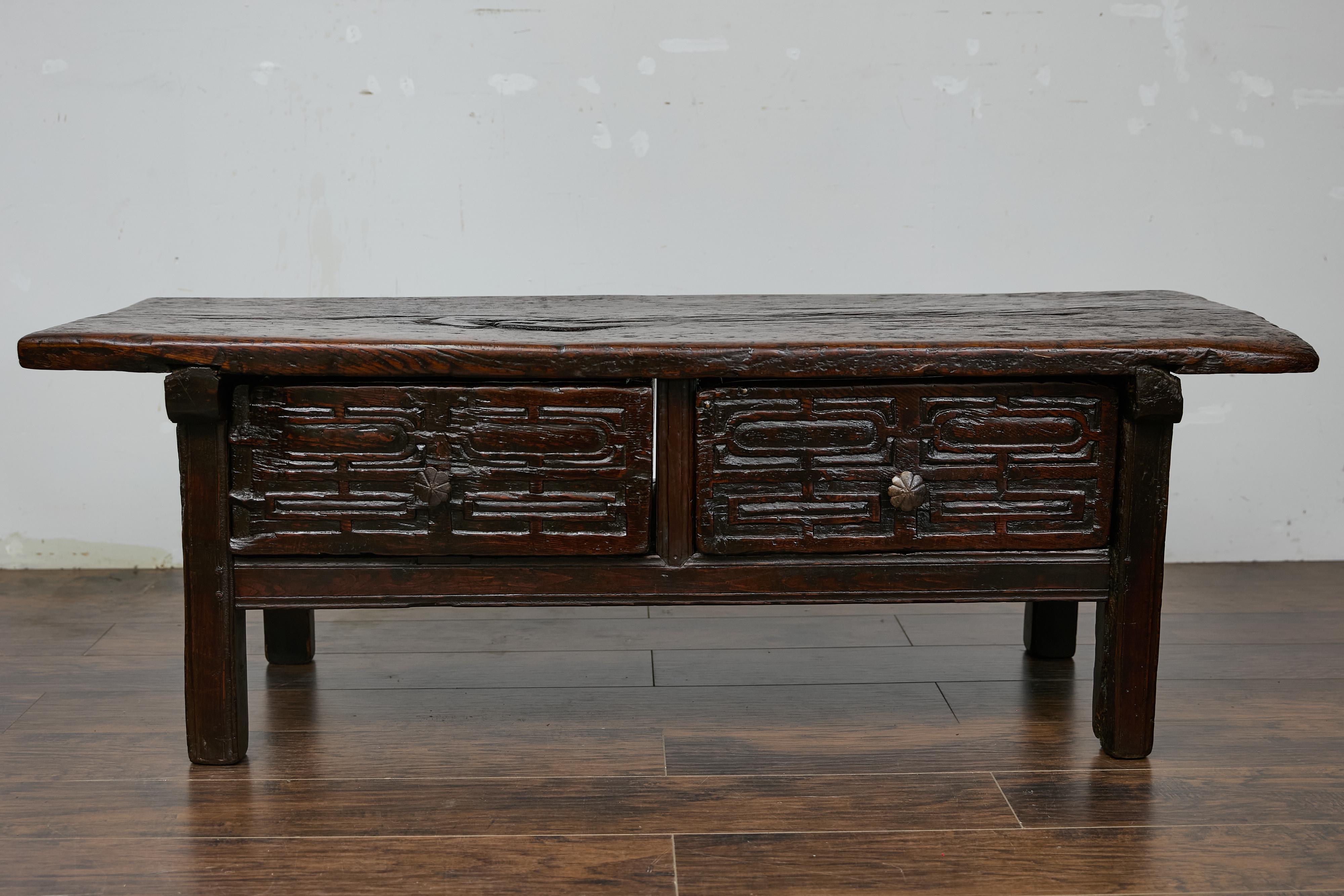 Table basse en chêne espagnol du début du 19e siècle avec deux tiroirs et un décor sculpté. Cette table ancienne en chêne espagnol, datant d'environ 1800, est un magnifique mélange de fonctionnalité et d'élégance rustique, témoignant d'un