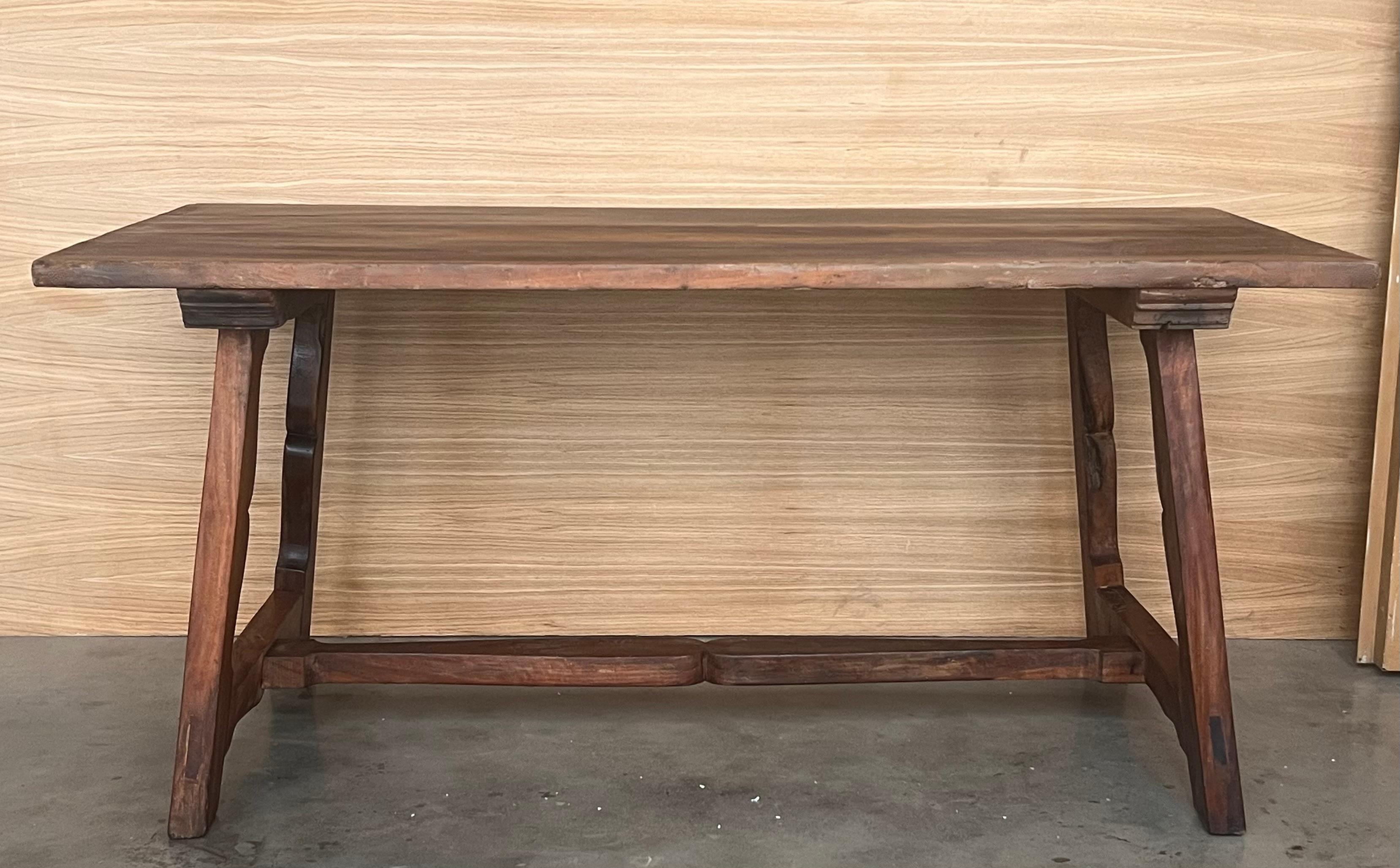 Tavolo da pranzo in noce con gambe intagliate e piano d'appoggio. Le gambe spagnole sono unite da una cornice in legno originale del XIX secolo.
È perfetto da usare come tavolo da lavoro.