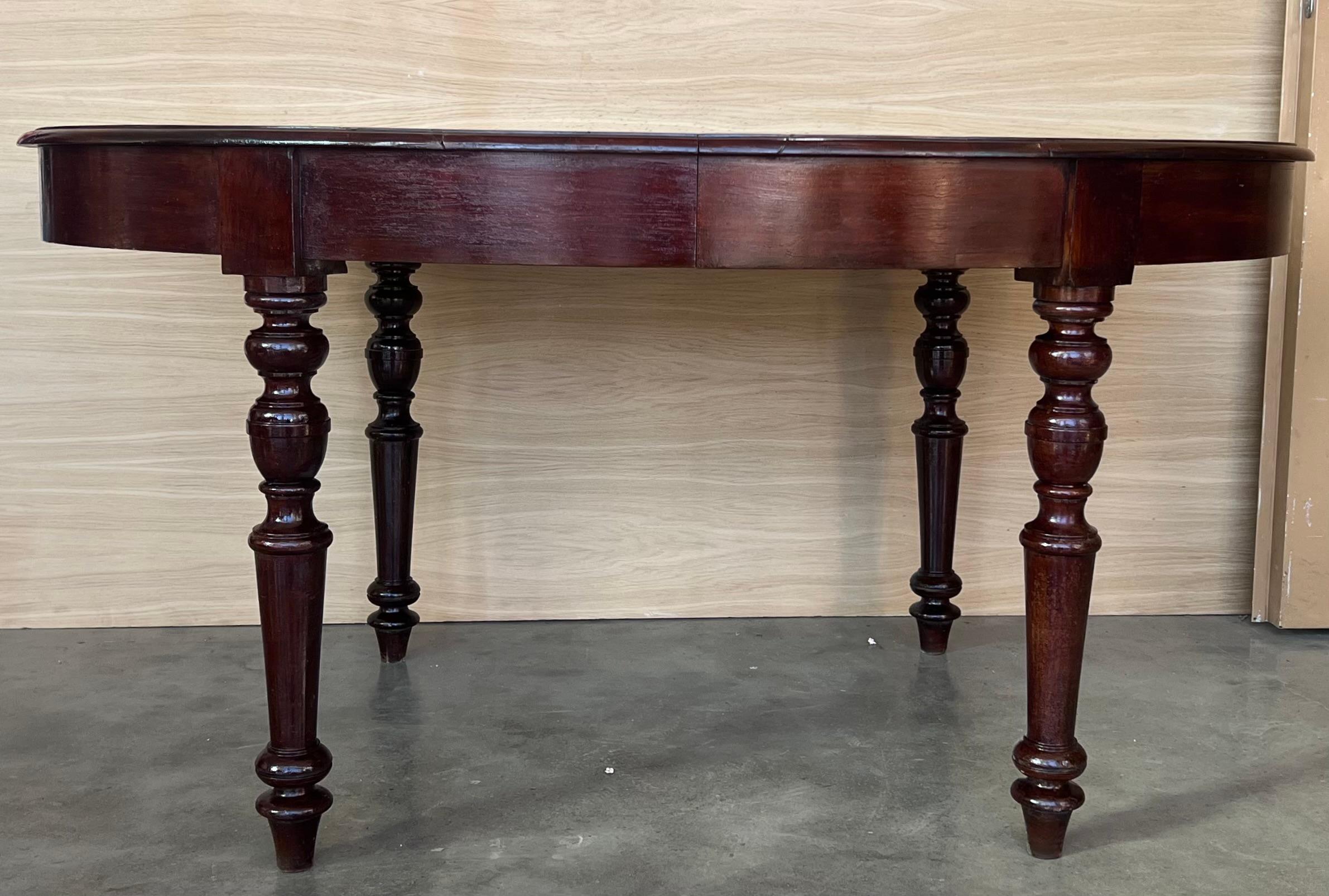 Ancienne table de salle à manger à quatre pieds en noyer sculpté espagnol. Circa 1900. Le plateau est rond, la jupe est perlée et les quatre pieds de la base surélevée renforcent la table.

