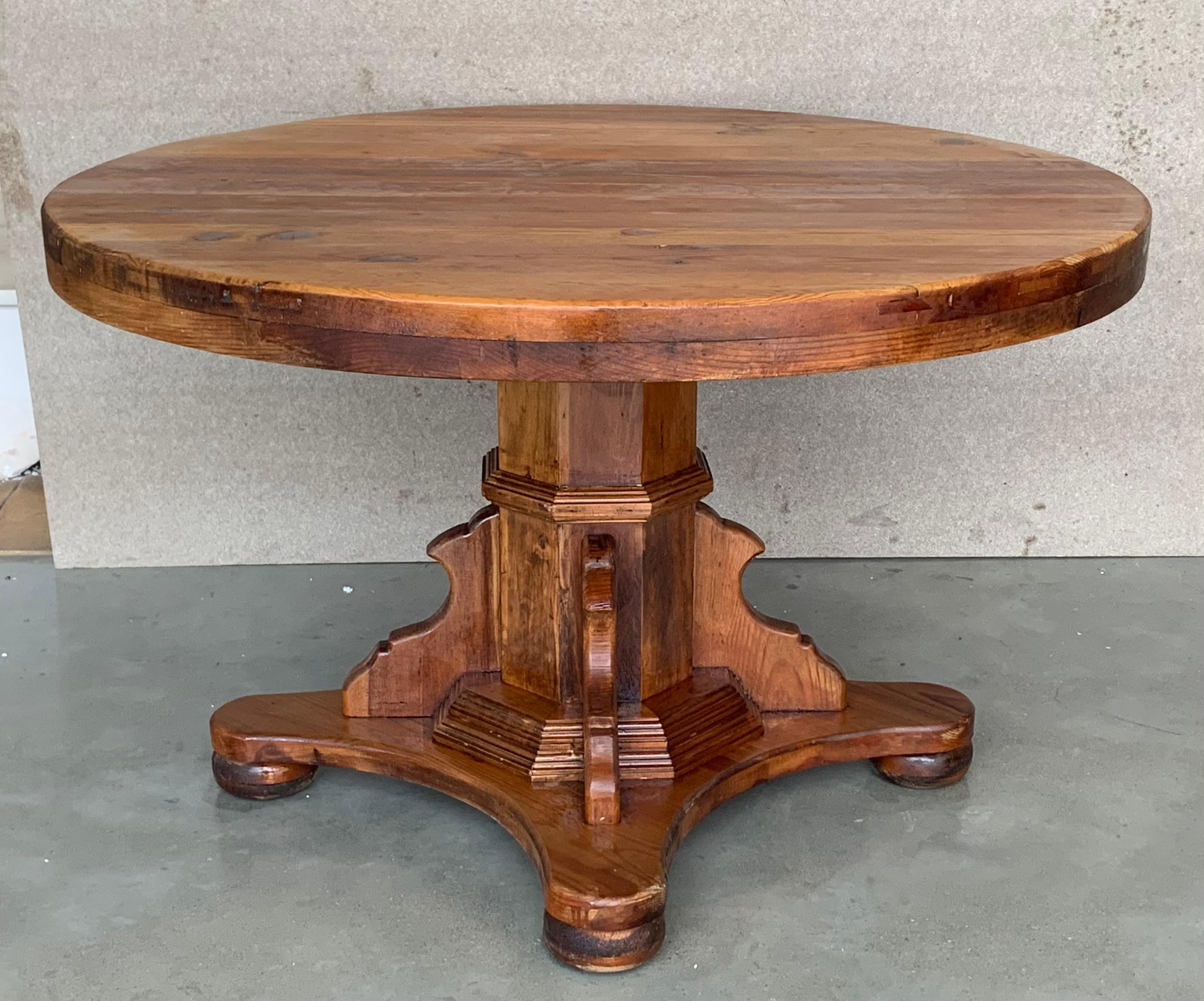An antique Spanish pine ( called mobile) Carved pedestal dining table. Circa 1900. Having a round top over a beaded skirt, rising on a hexagonal pedestal, four stretches on the raised base to reinforce the table.