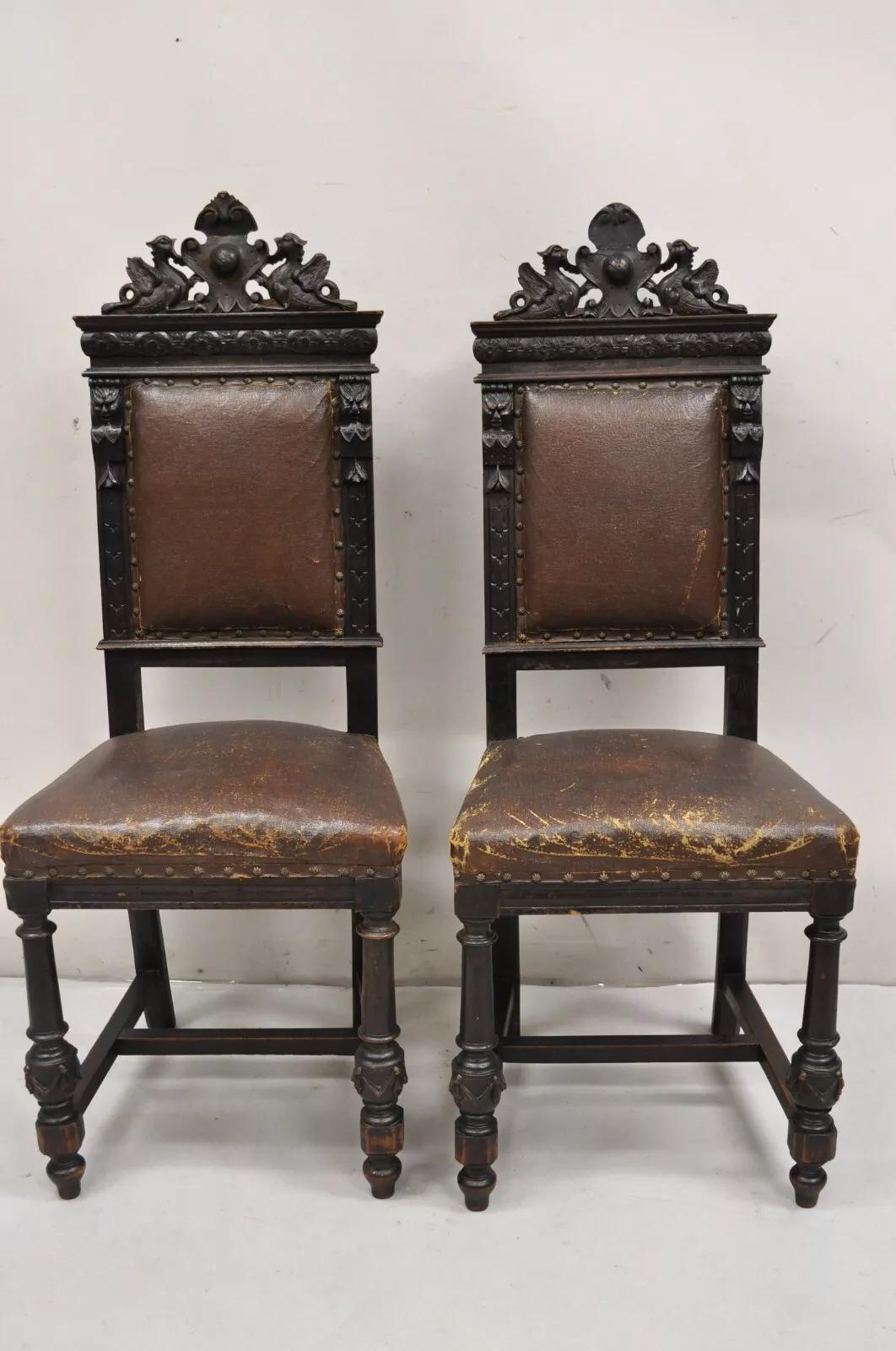 Antique Spanish Renaissance Carved Oak Wood Figural Leather Upholstered Side Chairs - a Pair. Chairs feature carved faces and brown distressed leather upholstery, very nice decorative antique chairs. Circa Mid 19th Century. Measurements: 45