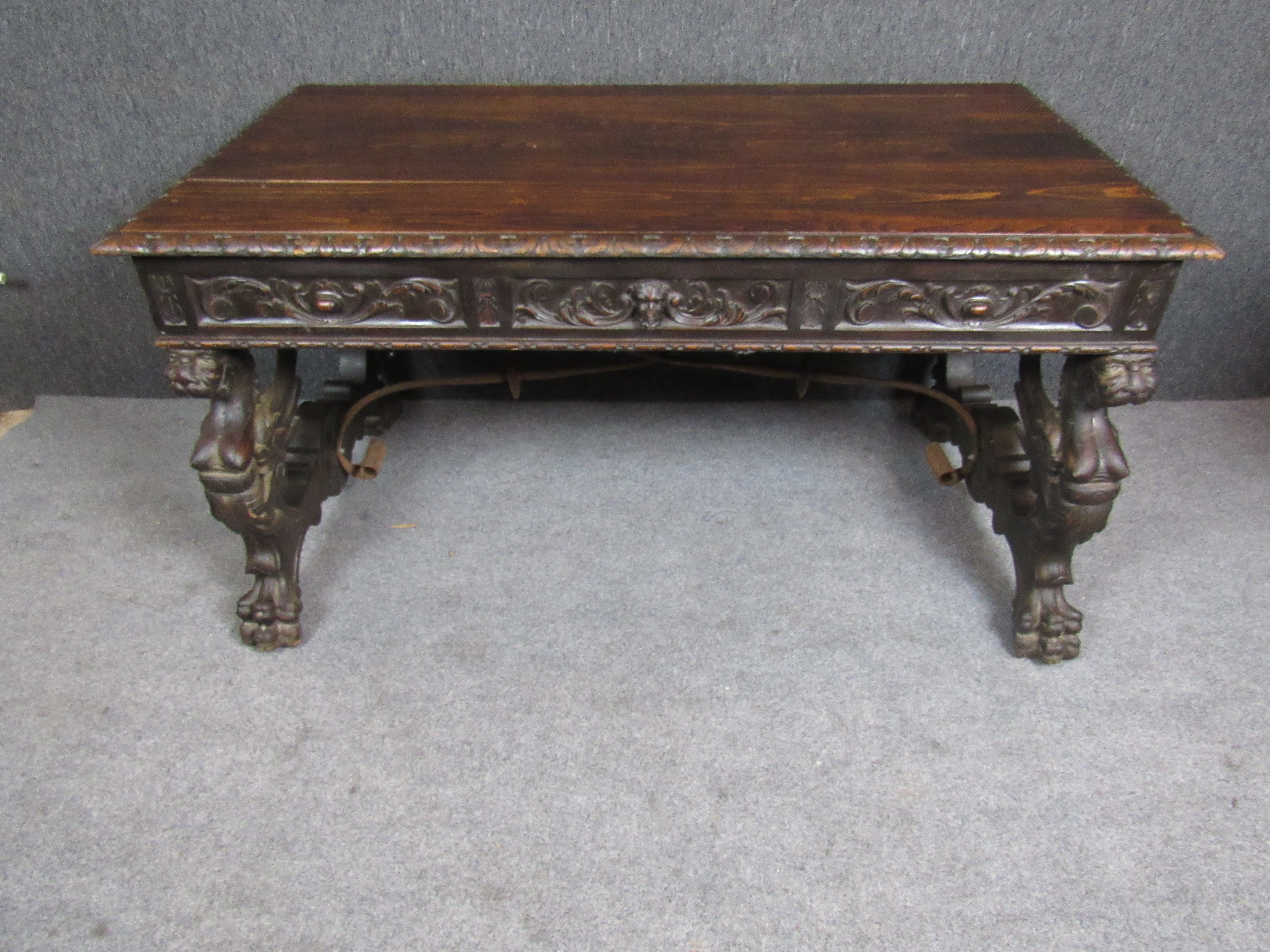 Here is a once in a lifetime antique Spanish hand-carved oak desk with striking gothic details. Featuring an imposing, mythical Griffin base, three beautifully sculpted gargoyle drawers, and an ample table top, this desk is sure to make a bold