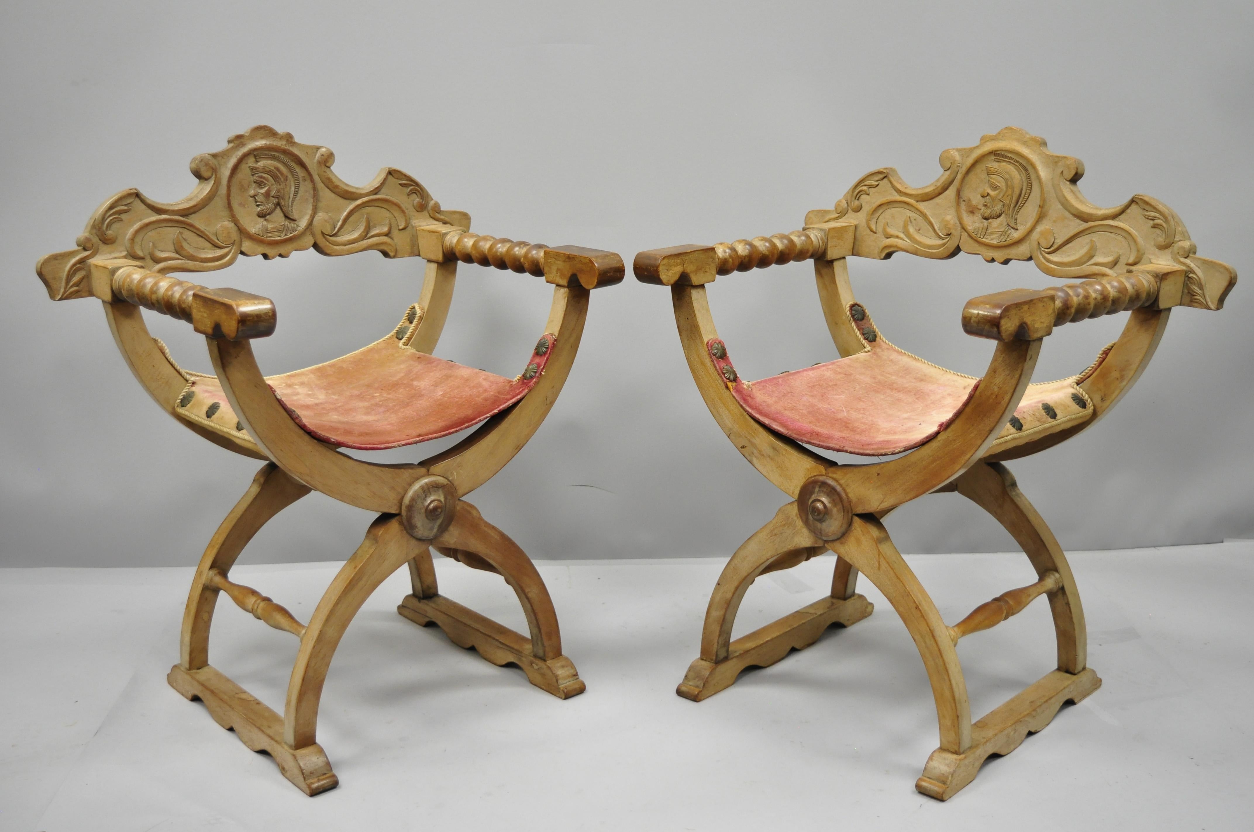 A pair of antique Spanish Renaissance curule Savonarola throne chairs. Item features lift out back, solid wood construction, pink velvet upholstered seat, and nicely carved details, circa late 19th-early 20th century. Measurements: 32