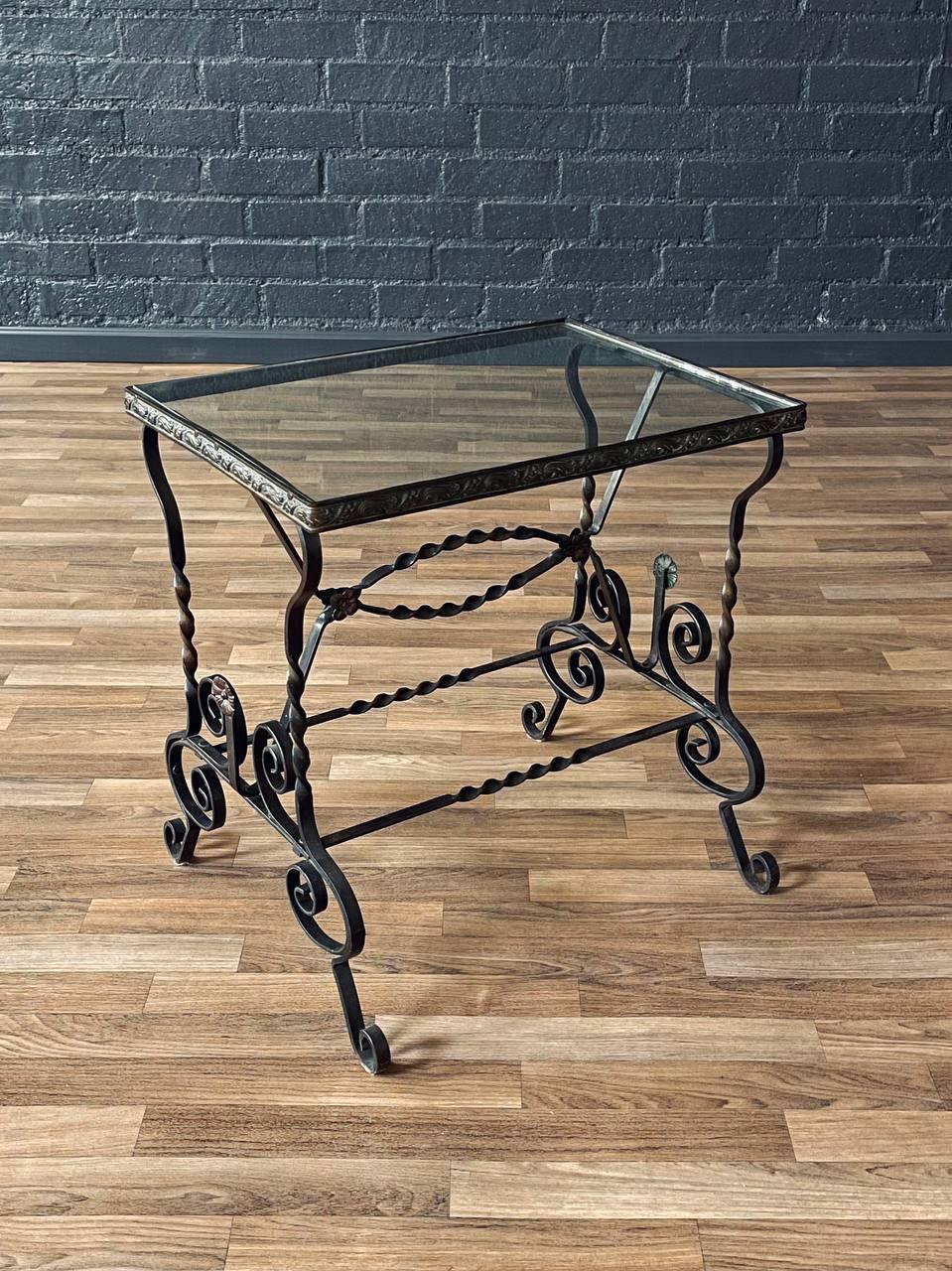 Style: Spanish Revival
Materials: Wrought Iron, Original Glass Top

This striking Spanish Revival side table from the 1940s showcases masterfully hand-forged wrought iron construction paired with its original glass top. The frame features twisted
