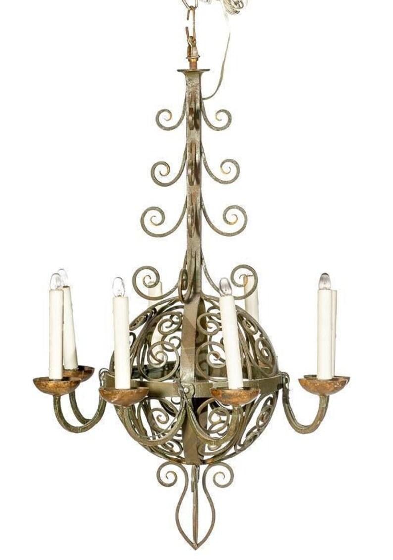 An incredible and rare Spanish Revival painted wrought iron large chandelier from the mid 19th to early 20th century. Having eight arms ending in faux candle lights, original green paint with wonderful rustic patina, featuring a globe sphere with
