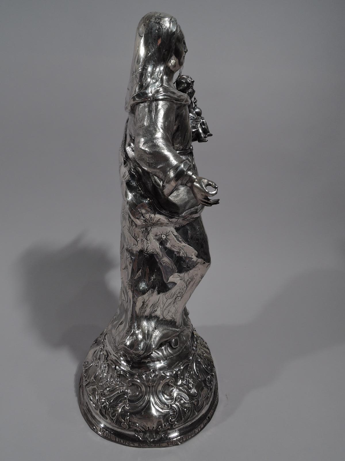 Spanish Rococo silver figure of Virgin Mary and Child, late 18th century. Mary, in loose gown and sumptuous cloak gathered at hip, stands with one arm outstretched and the other supporting Jesus, who holds the orb and cross in his infant palm and