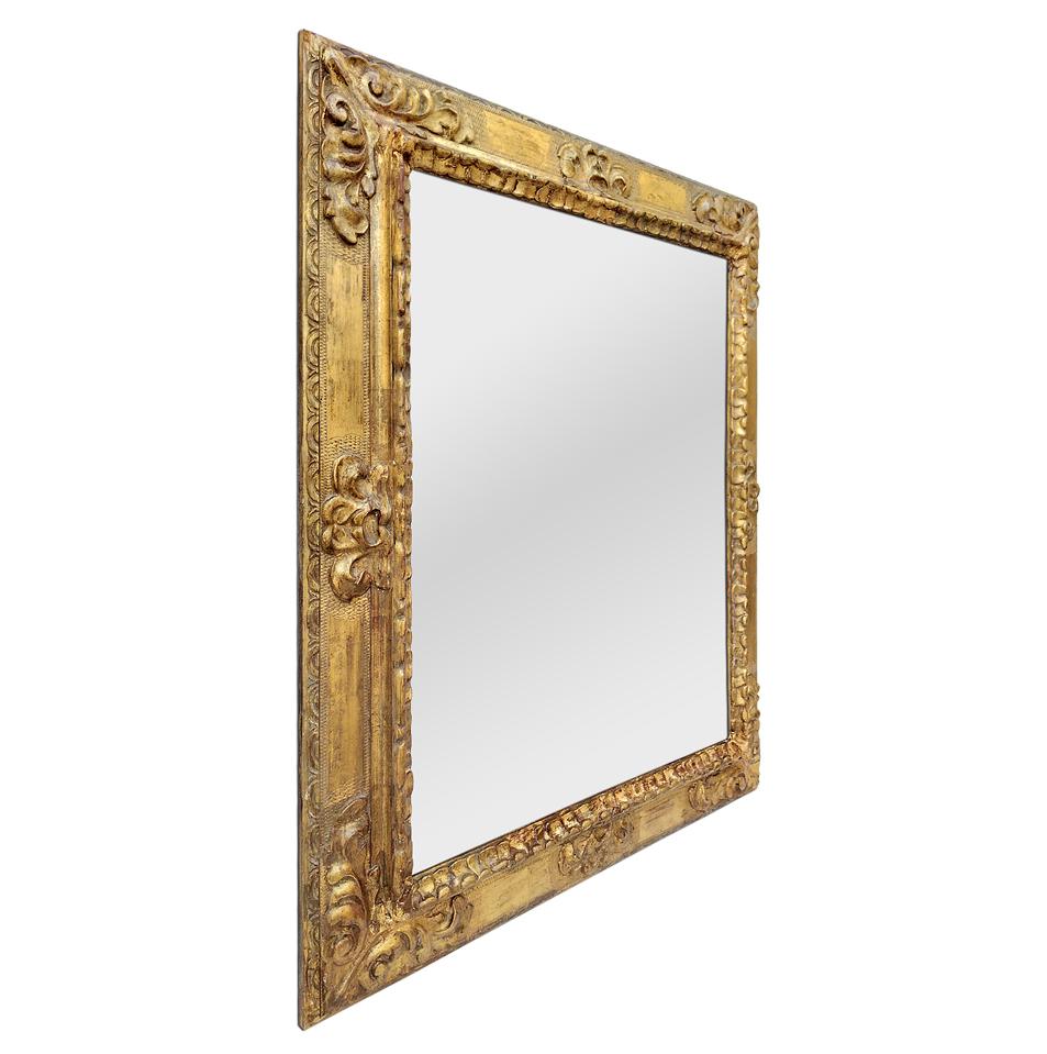 Antique Spanish style mirror frame from the 1930s. Sculpted decoration in plaster on a wooden upright. Original gilding with gold leaf. Modern glass mirror. Antique frame width 11 cm / 4.33 in.