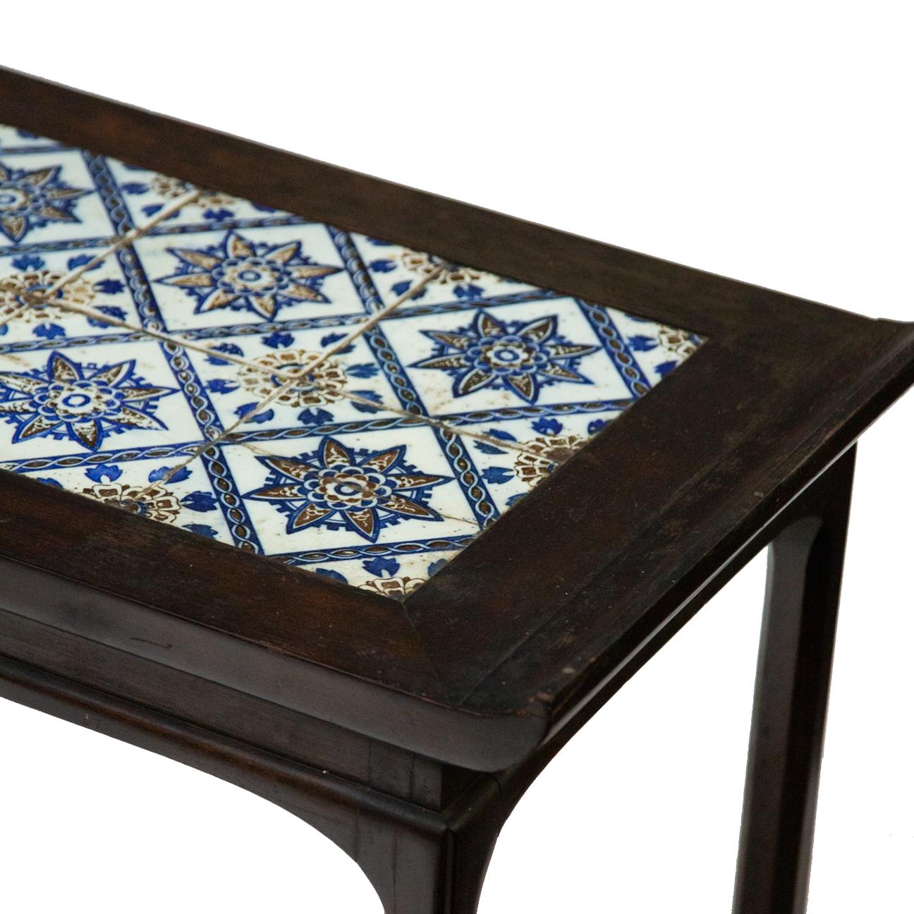 Antique Spanish tile on Chinese style table. Blue and white Spanish tiles mounted on top of Chinese style wooden table. Measures: 17.25 W x 39.5 L x 19