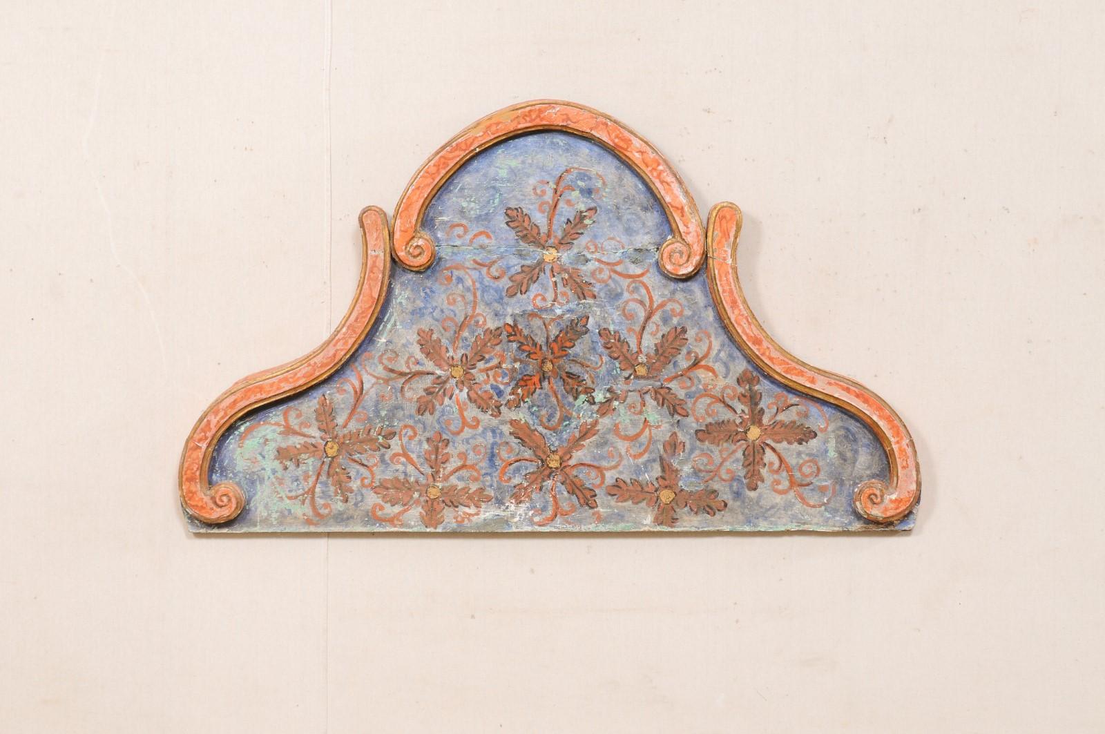 A Spanish carved-wood wall hanging pediment with it's original painted finish from the 19th century. This antique wooden architectural plaque, which is approximately 4.25 feet in length, has an arched shape which is framed with three raised delicate