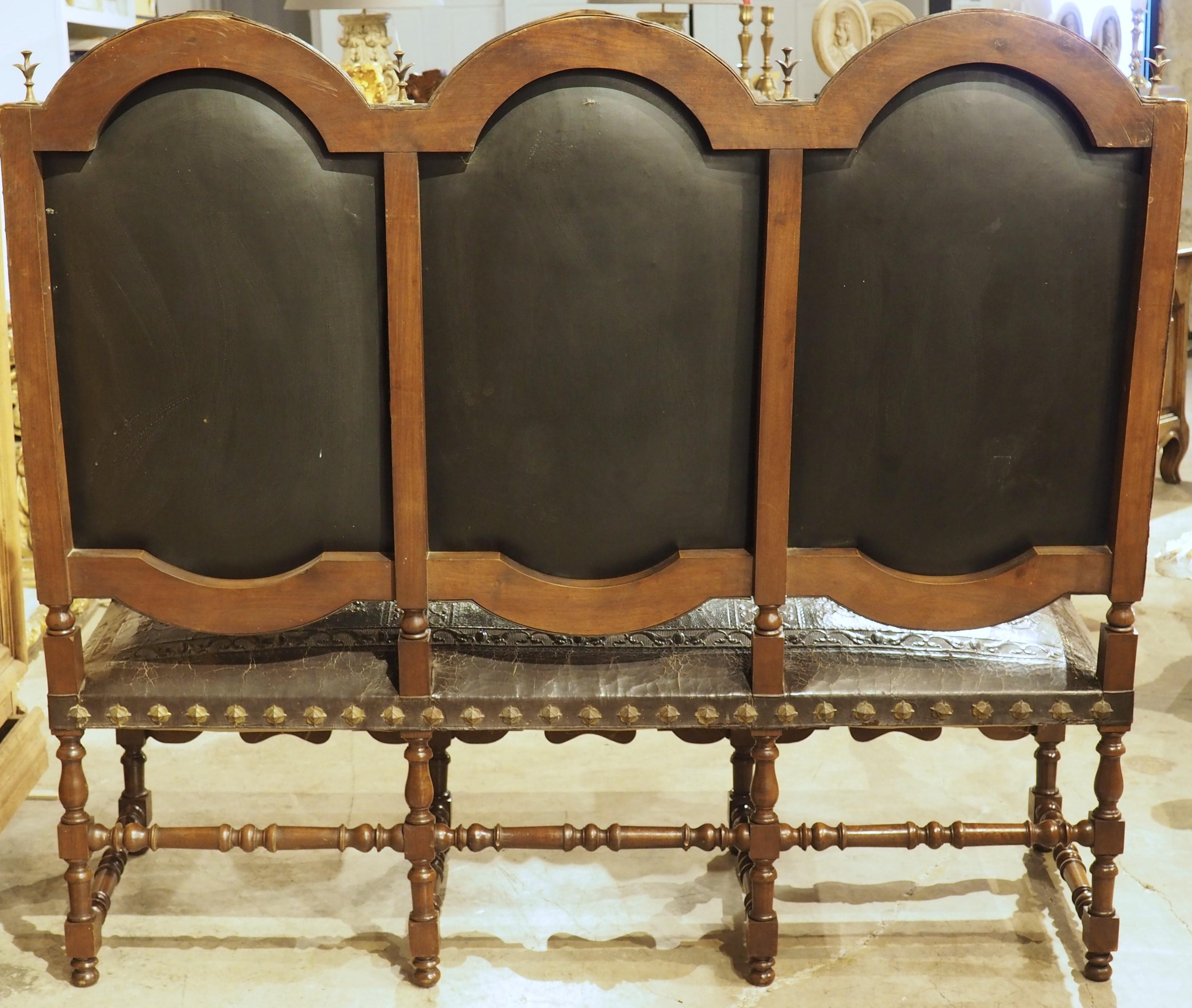 Moderne et fonctionnel, ce banc espagnol des années 1800 est soutenu par un cadre en noyer bien sculpté et peut accueillir trois adultes. Le cuir gaufré recouvre l'assise, ainsi que les trois dossiers, qui sont contigus et surmontés d'une série