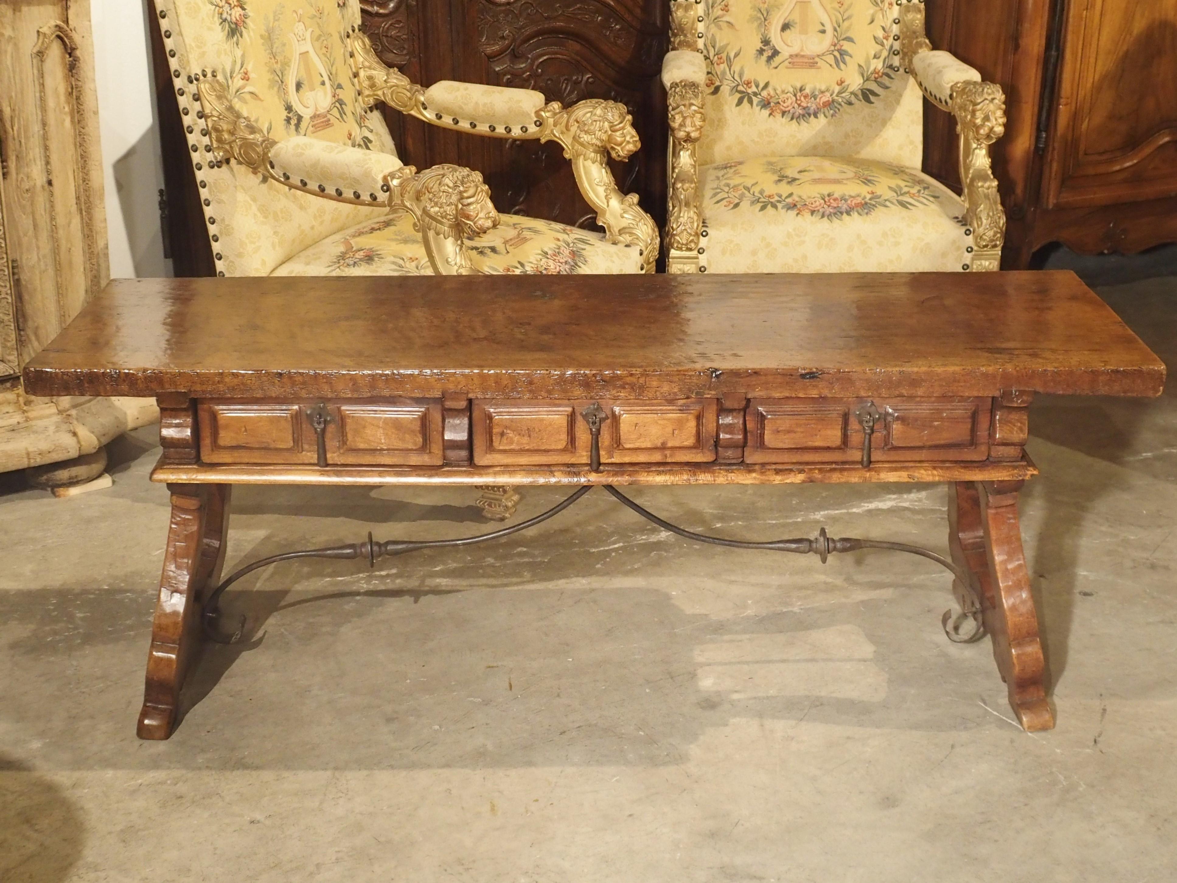This wonderful walnut wood coffee table from Spain dates to the 1600s, although around the turn of the last century, the legs were replaced to form a coffee table (Low coffee tables only came to be in the late 1800s). The top is one plank of walnut