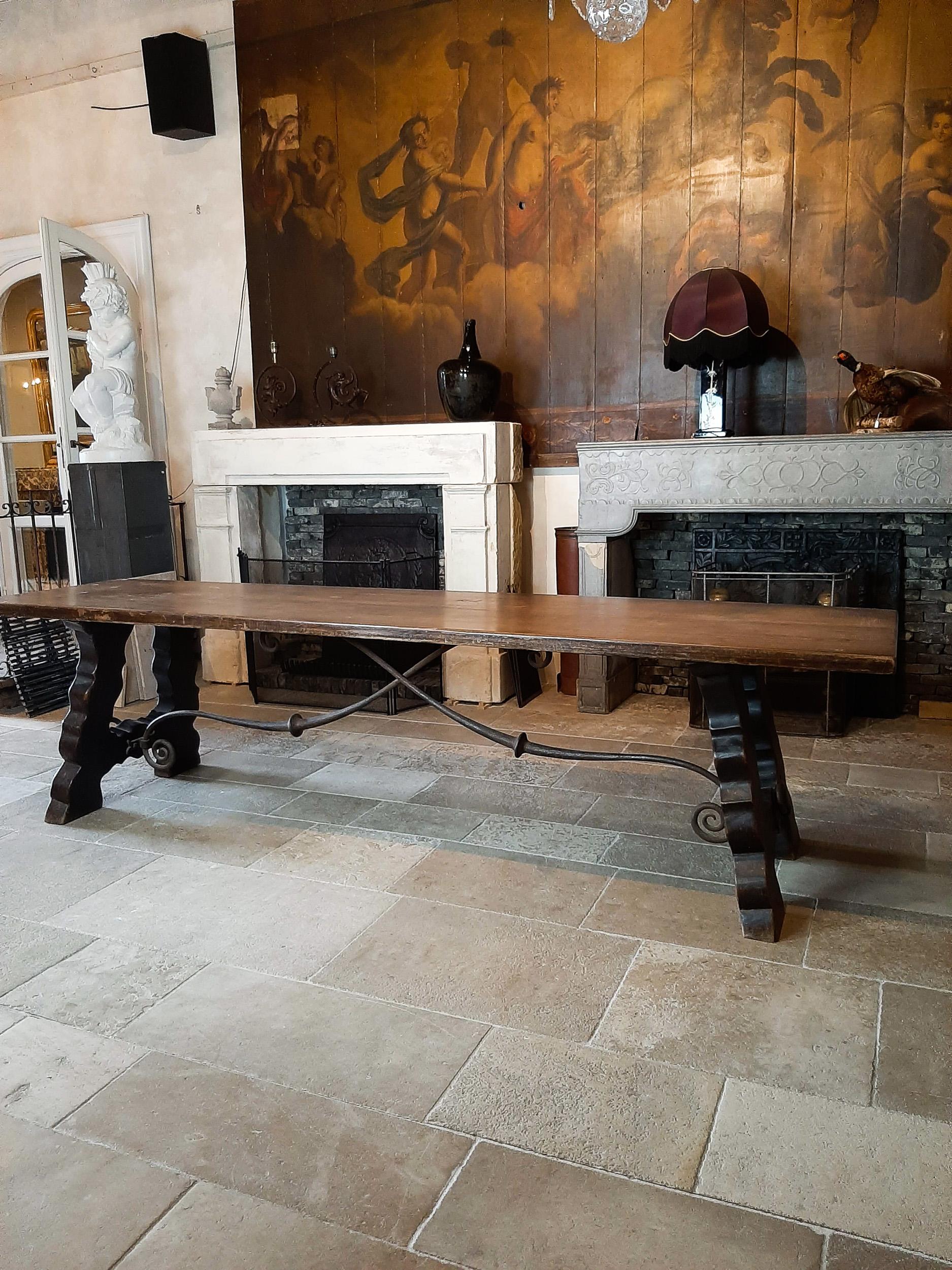 Robuste et élégante table de salle à manger espagnole en bois du XIXe siècle, à la patine usée, avec de magnifiques supports en fer forgé à la main dans la base.

Espagnol, mexicain, style Cortijo Ibiza.

Cette table espagnole du XIXe siècle est