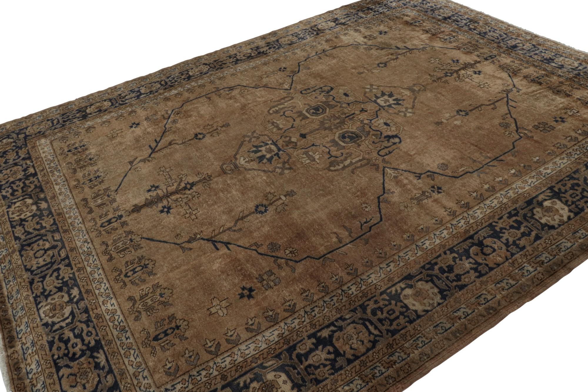 Hand-knotted in wool, this 8x11 antique Turkish Isparta rug, circa 1920-1930, enjoys rich brown and navy blue tones in archaic geometric floral patterns. 

On the Design: 

Originating from the titular region of Turkey, this Isparta rug (sometimes