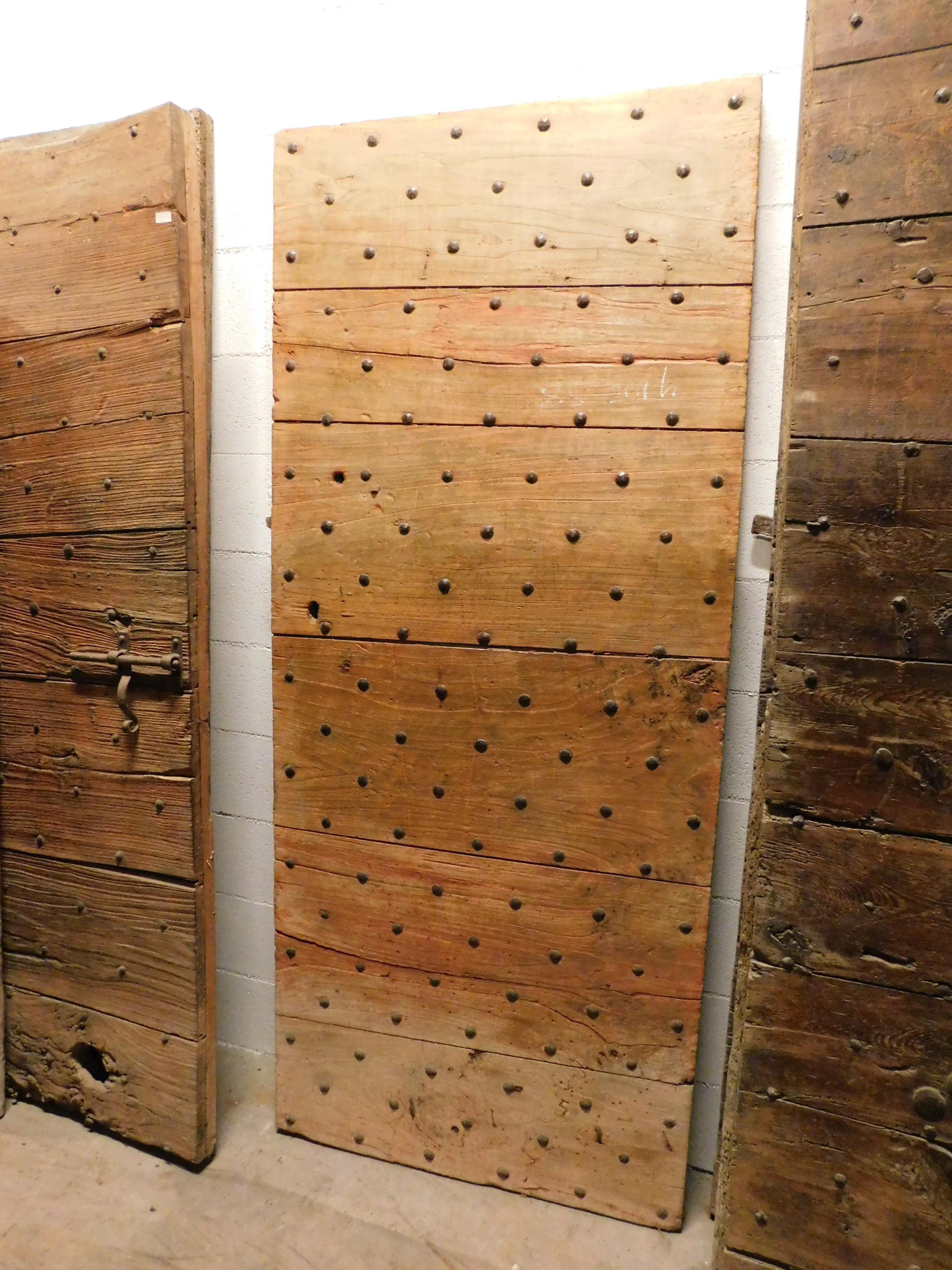 Antique interior door or entrance door (given the thickness) with original nails, built in poplar in the 19th century for a rustic farmhouse in Italy.
Smooth back, with only irons, original iron lock and handle, therefore the possibility of making