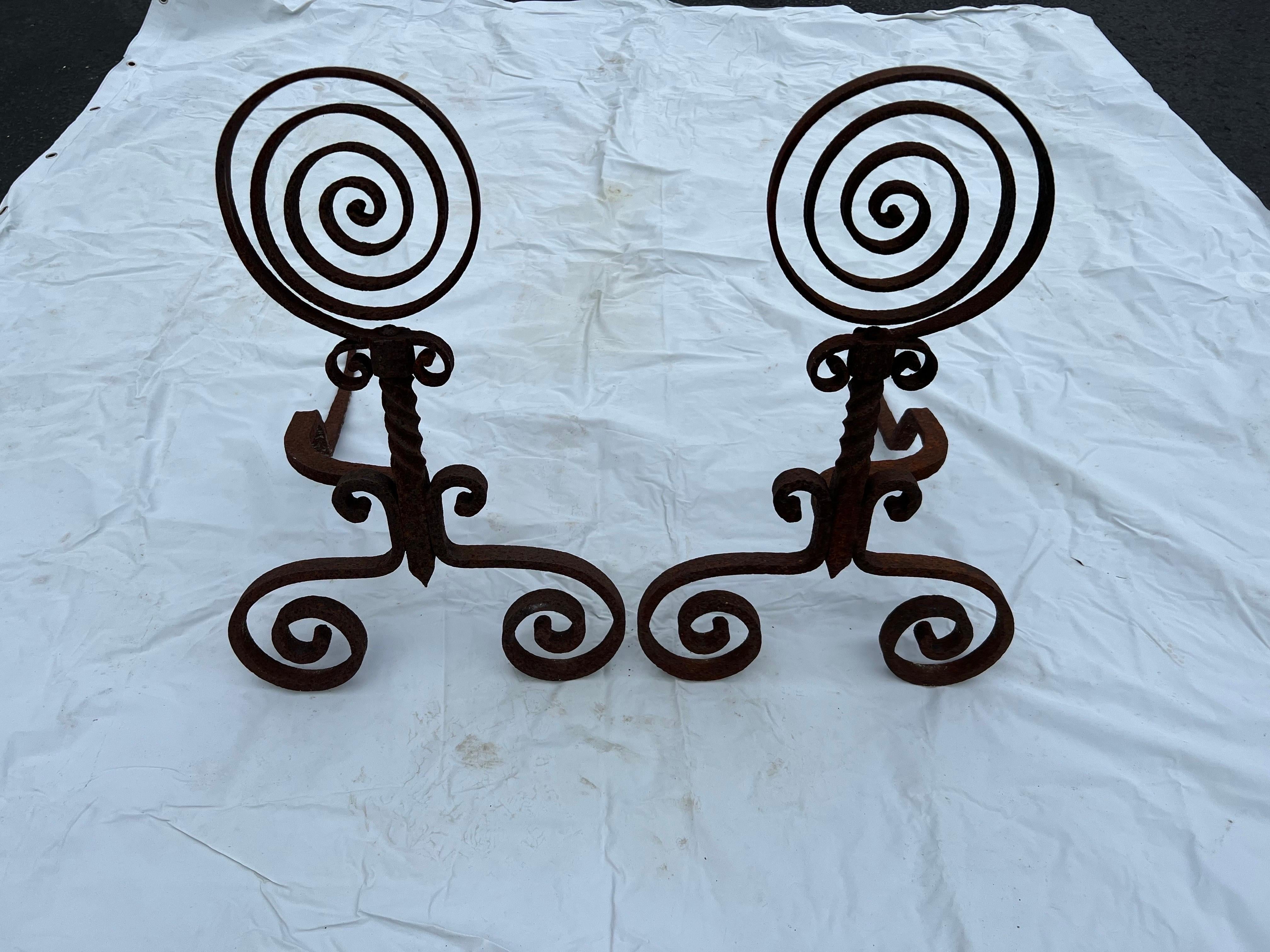 Pair of Spiral Iron Fireplace Andirons. Primitive in style. Simple, round geometric spiral design. Please confirm dimensions prior to purchase. These can parcel ship very economically.