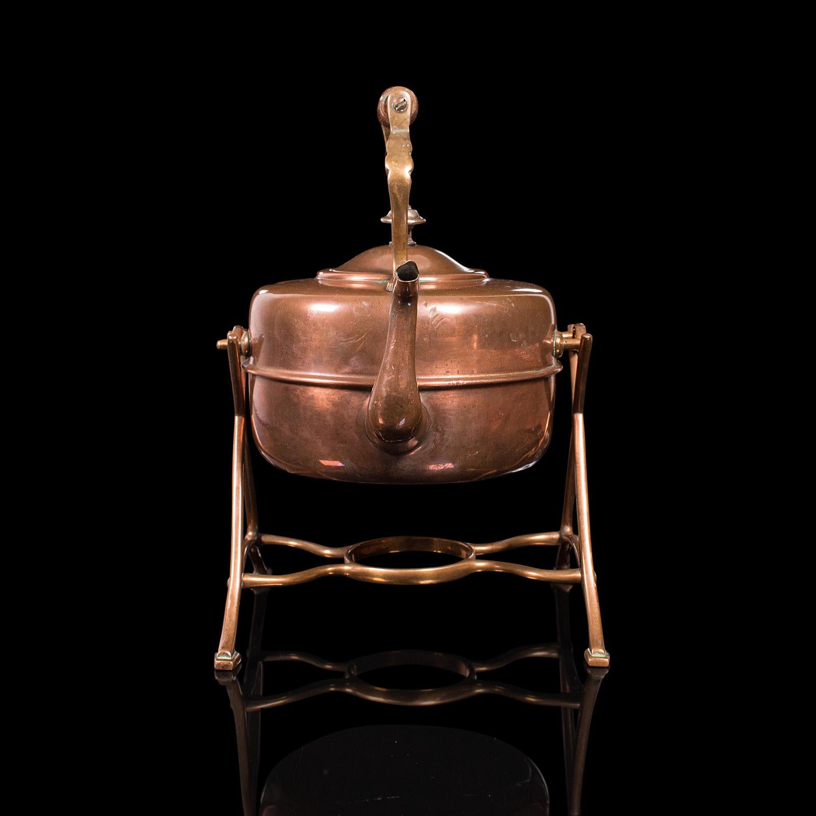 This is an antique spirit kettle. An English, copper and brass teakettle on stand, dating to the Victorian period, circa 1900.

Eye-catching antique kettle with fascinating stand
Displays a desirable aged patina throughout
Lightly polished