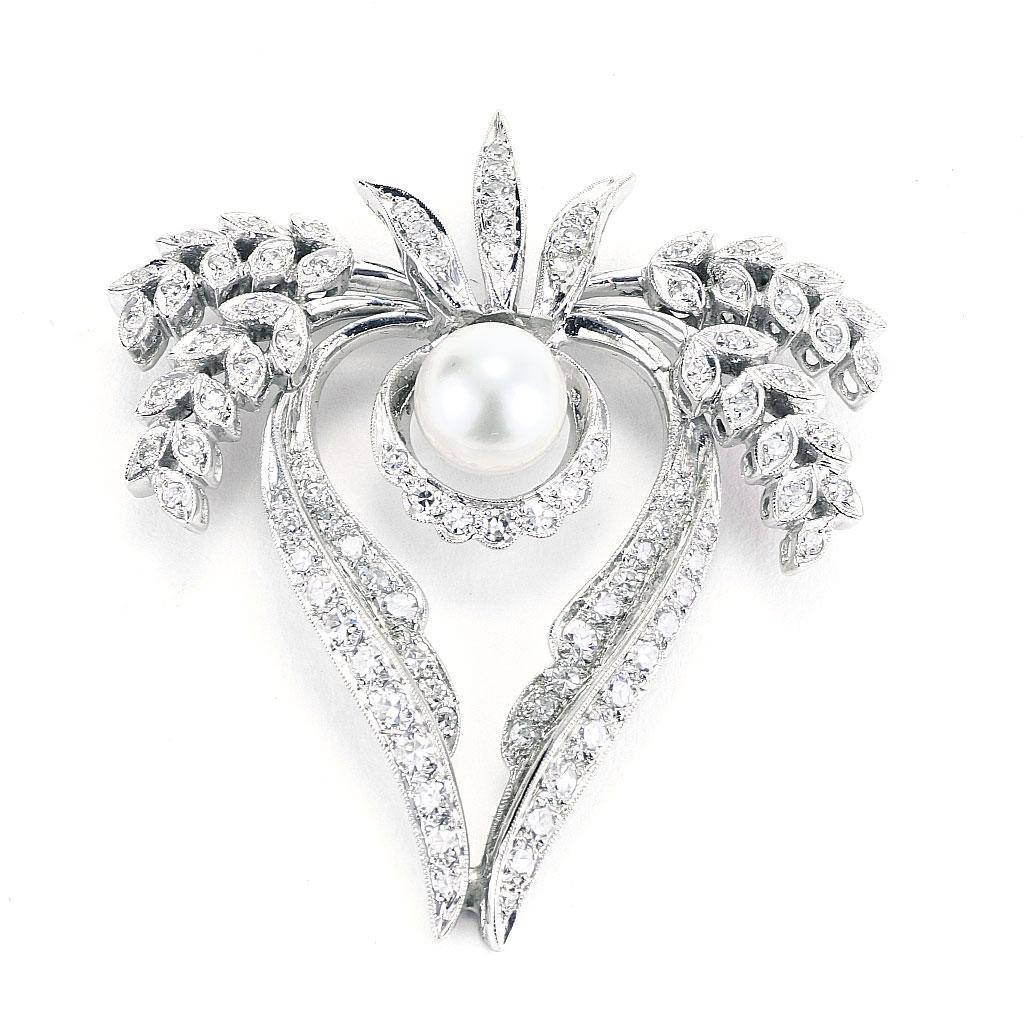 This pendant has a pin assembly and is made of 14K white gold and weighs 6.80 DWT (approx. 10.58 grams). It contains 93 single cut G-H color, VS clarity diamonds weighing 1.55 CTTW and one round pearl. Measures 2 inches long and 38 mm wide.