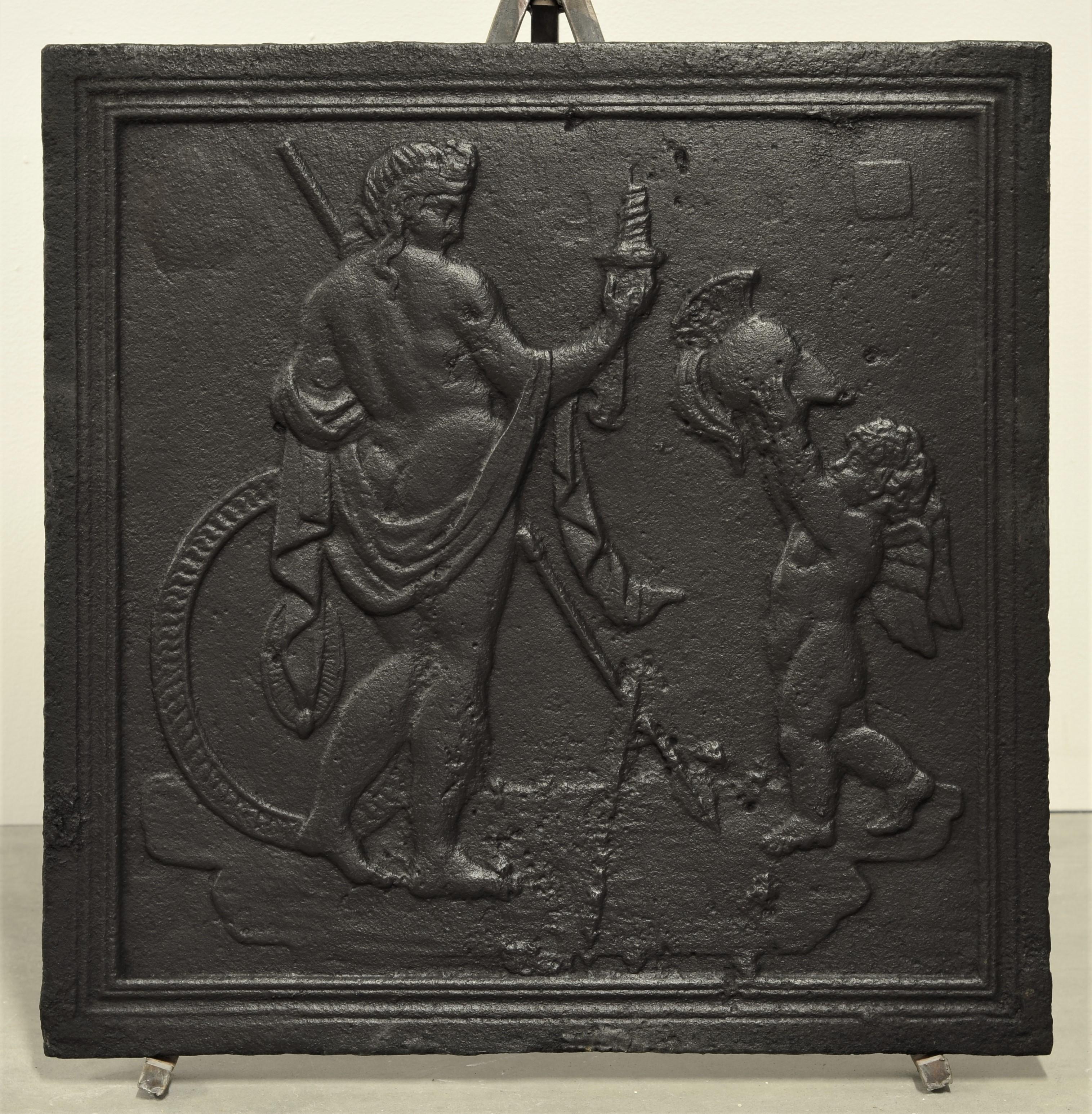 Decorative fireback showing a putti handing a warrior his helmet.
Pristine condition, very sharp casting

Perfect size for a working fire or as a nice backsplash.