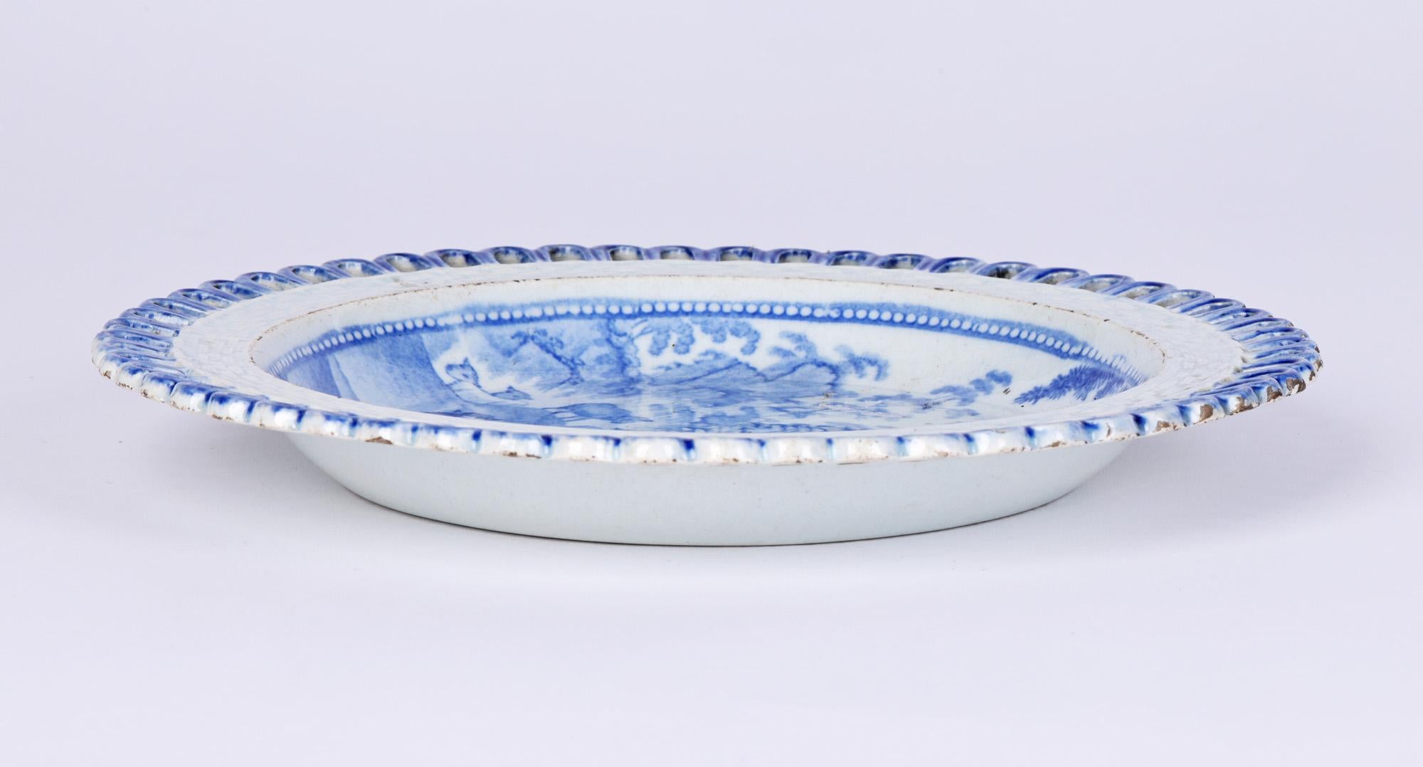 A very fine antique English Staffordshire pearlware blue and white plate decorated with a shepherd with his sheep dating from around 1820. The lightly potted plate is of round shape with a raised edge with a flat rim applied with openwork loops