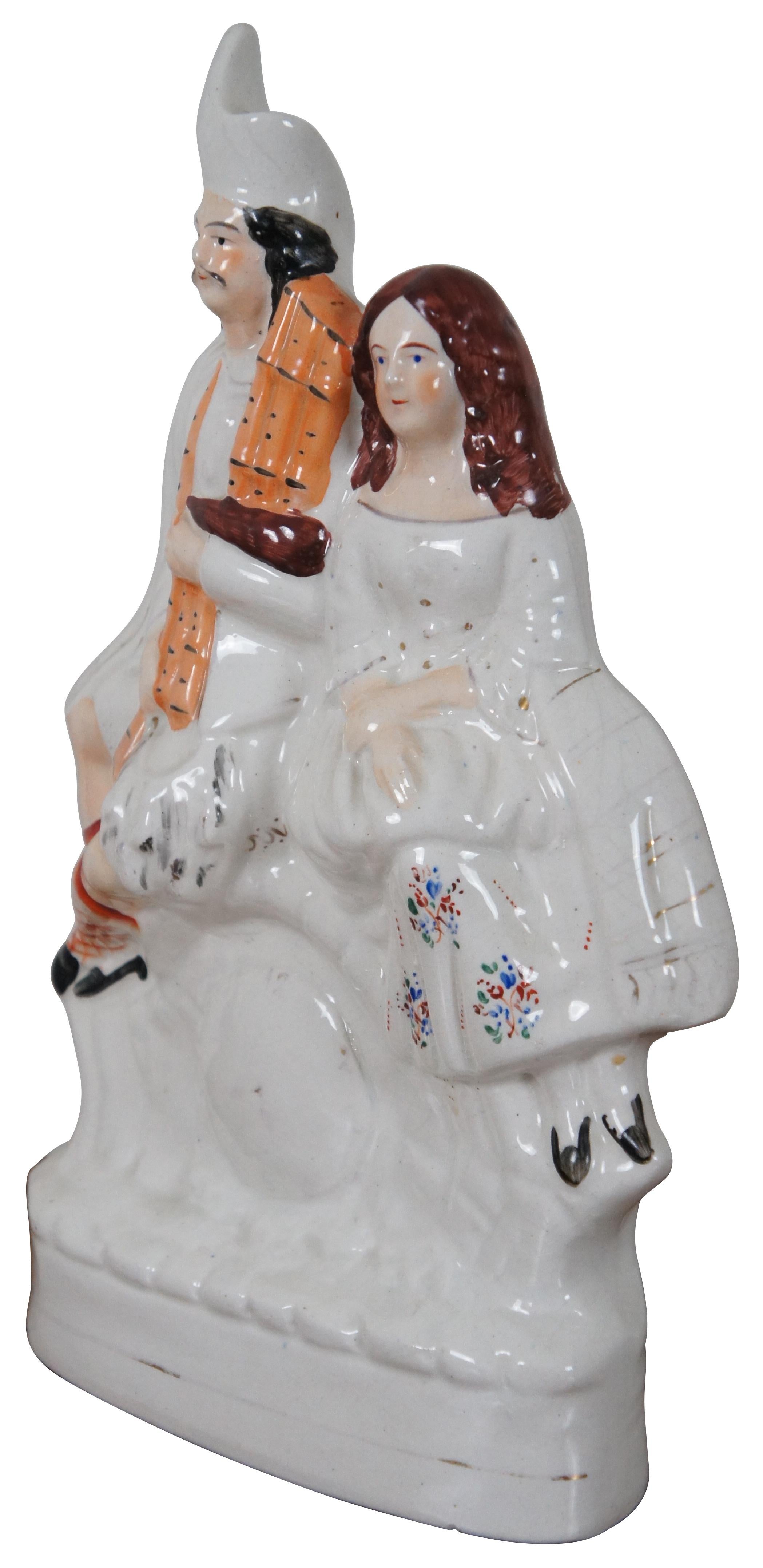 Antique circa 1870s Staffordshire porcelain figurine in the shape of a man and woman in Scottish clothing seated above a faux clock.