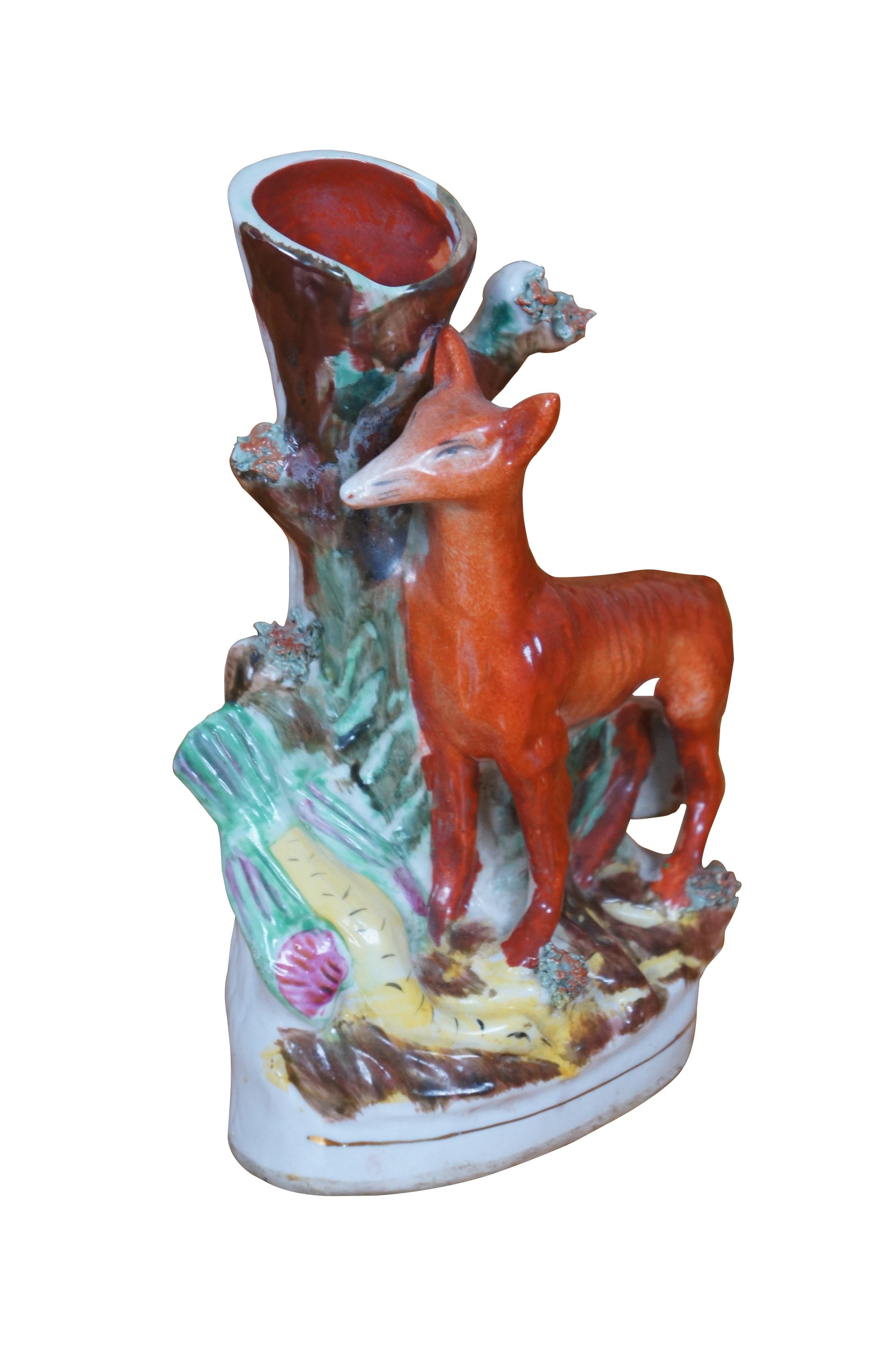 Antiguo jarrón de porcelana de Staffordshire que representa a un zorro rojo esbelto de pie junto a un tocón de árbol con un faisán de vivos colores tumbado a sus pies tras una exitosa cacería.

Dimensiones:
5,75